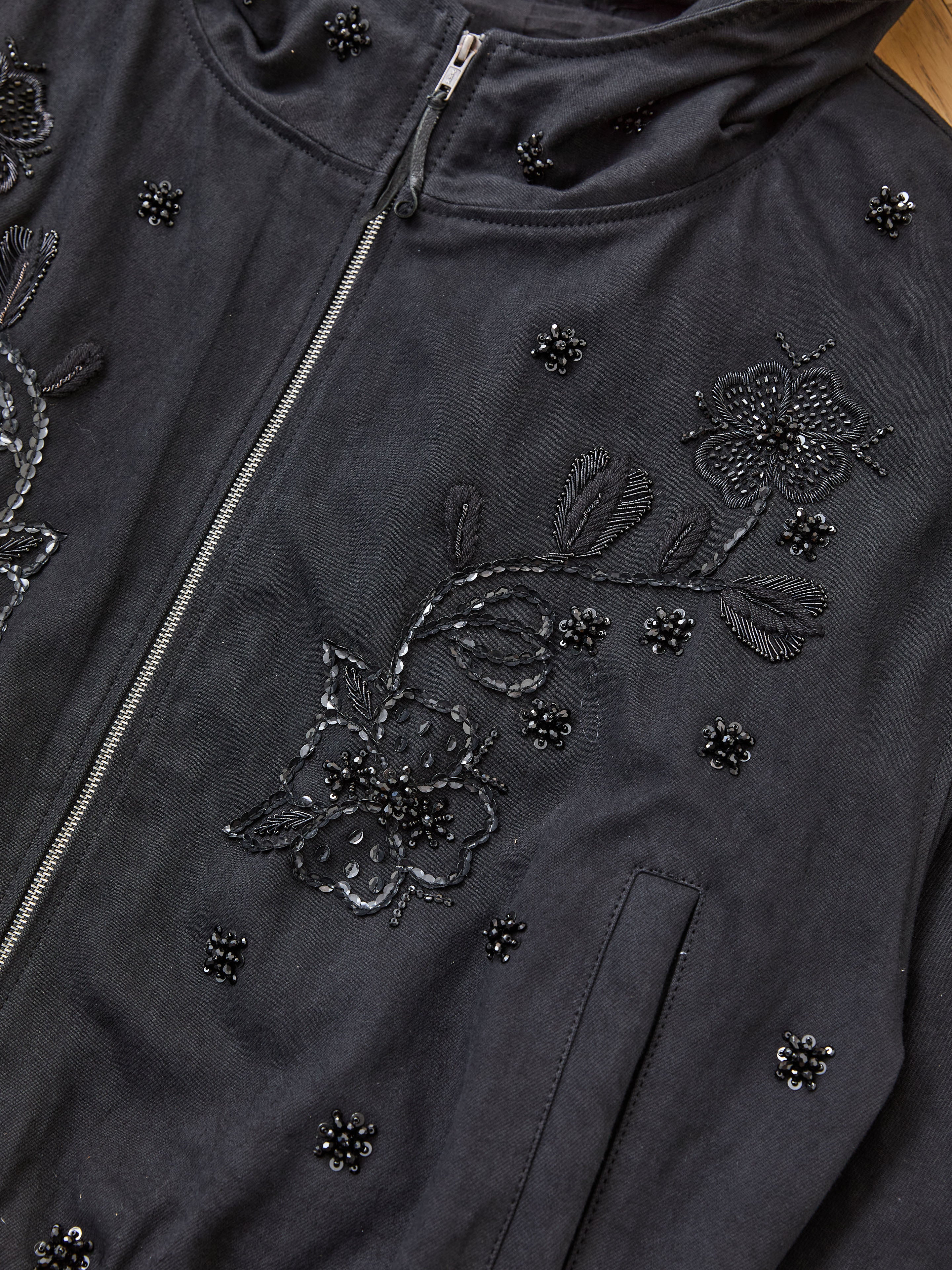 Close-up of the FOUND Hand Embroidered Tonal Anorak Jacket, a unisex cotton piece with Salma Sitara embroidery, beaded floral designs, visible zipper, and side pocket.