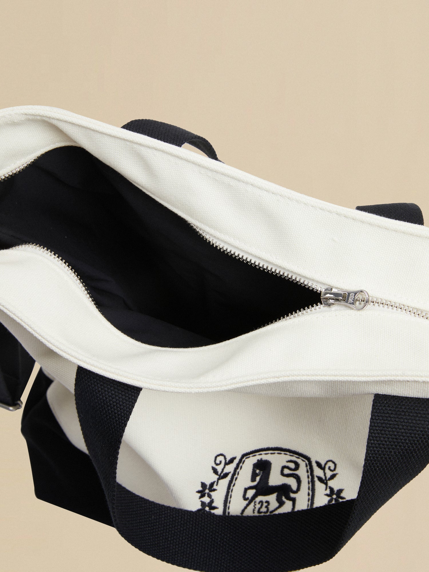 A white and black tote bag with the Profound horse logo crest on it.