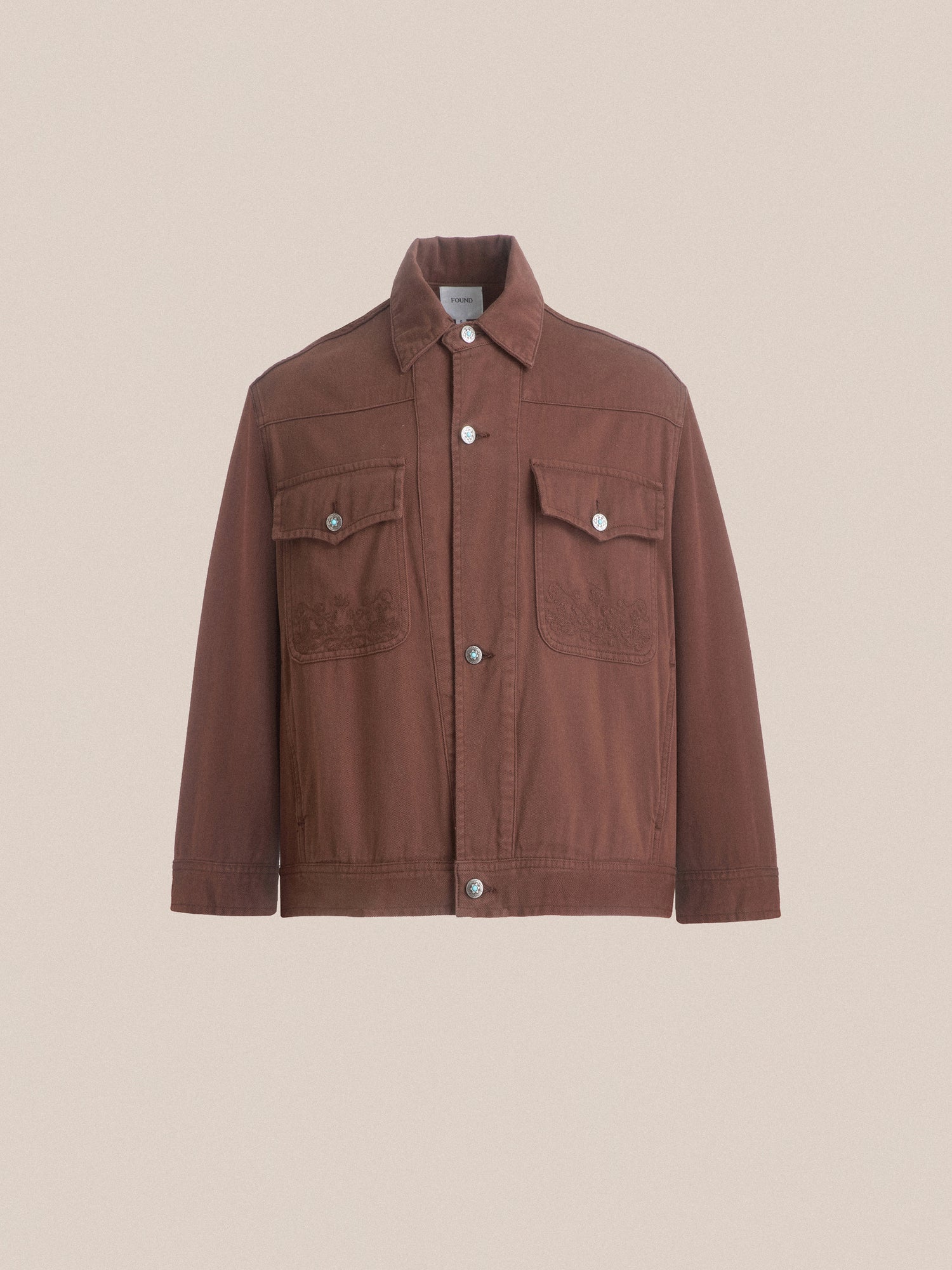 A brown Dusky Western Trucker Jacket with antique blue stone buttons on the front by Found.