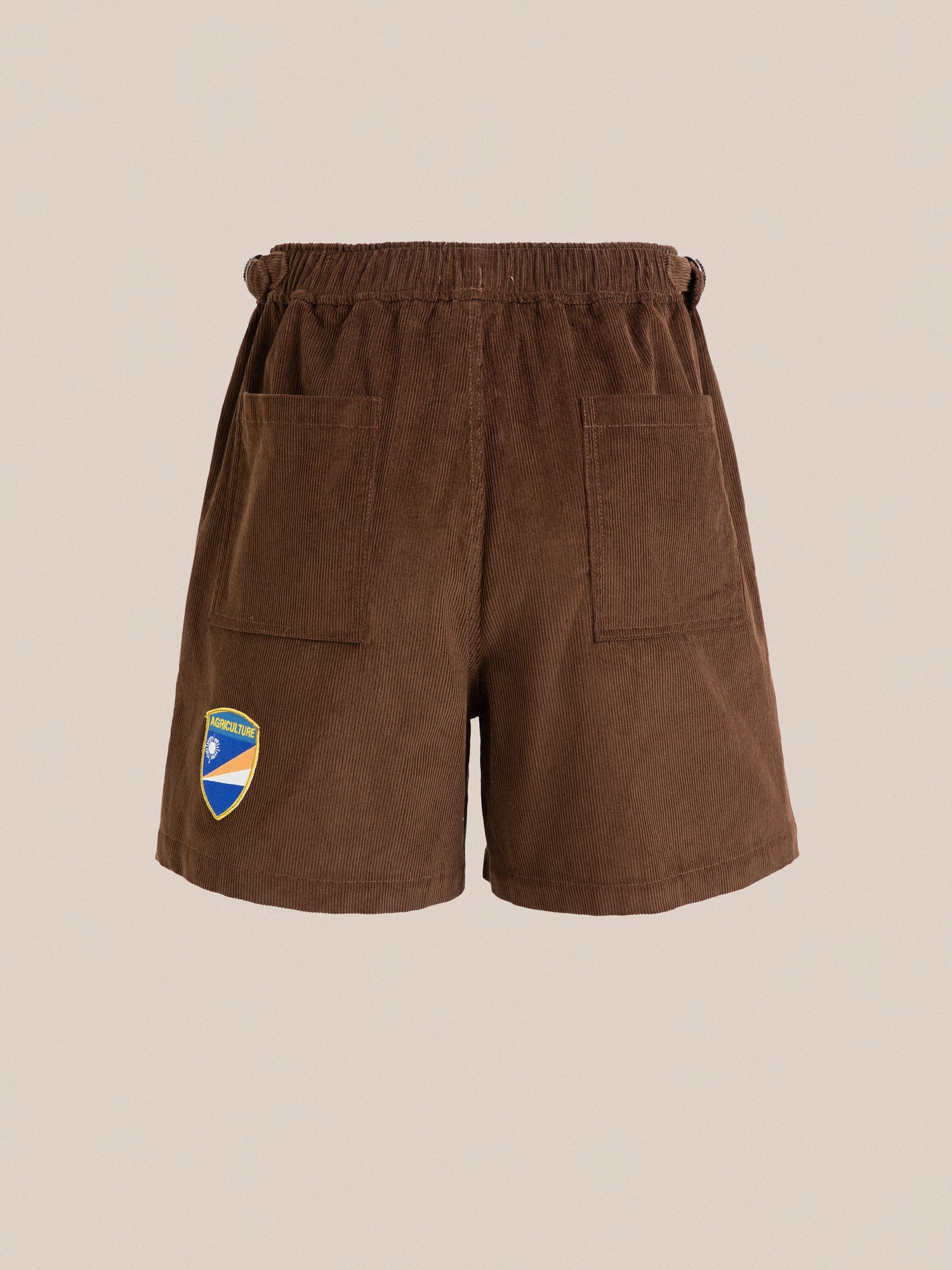 A brown Canoe Multi Patch Corduroy Shorts with a blue and yellow cricket sport crest patch by Found.