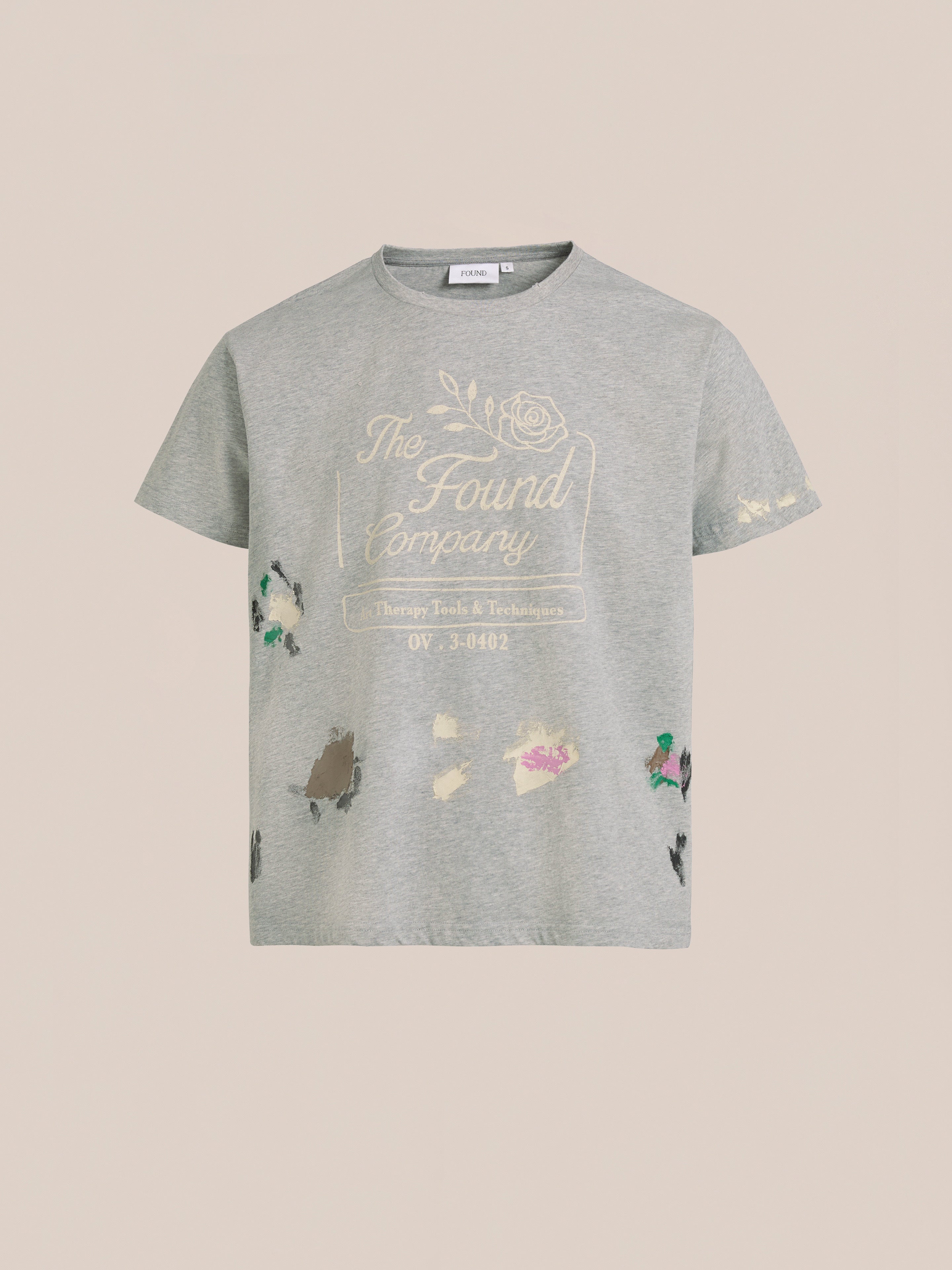 The FOUND Painters Company Tee is a gray vintage-style graphic t-shirt with "FOUND" text, a floral design, colorful paint splatters, and a unisex relaxed fit.