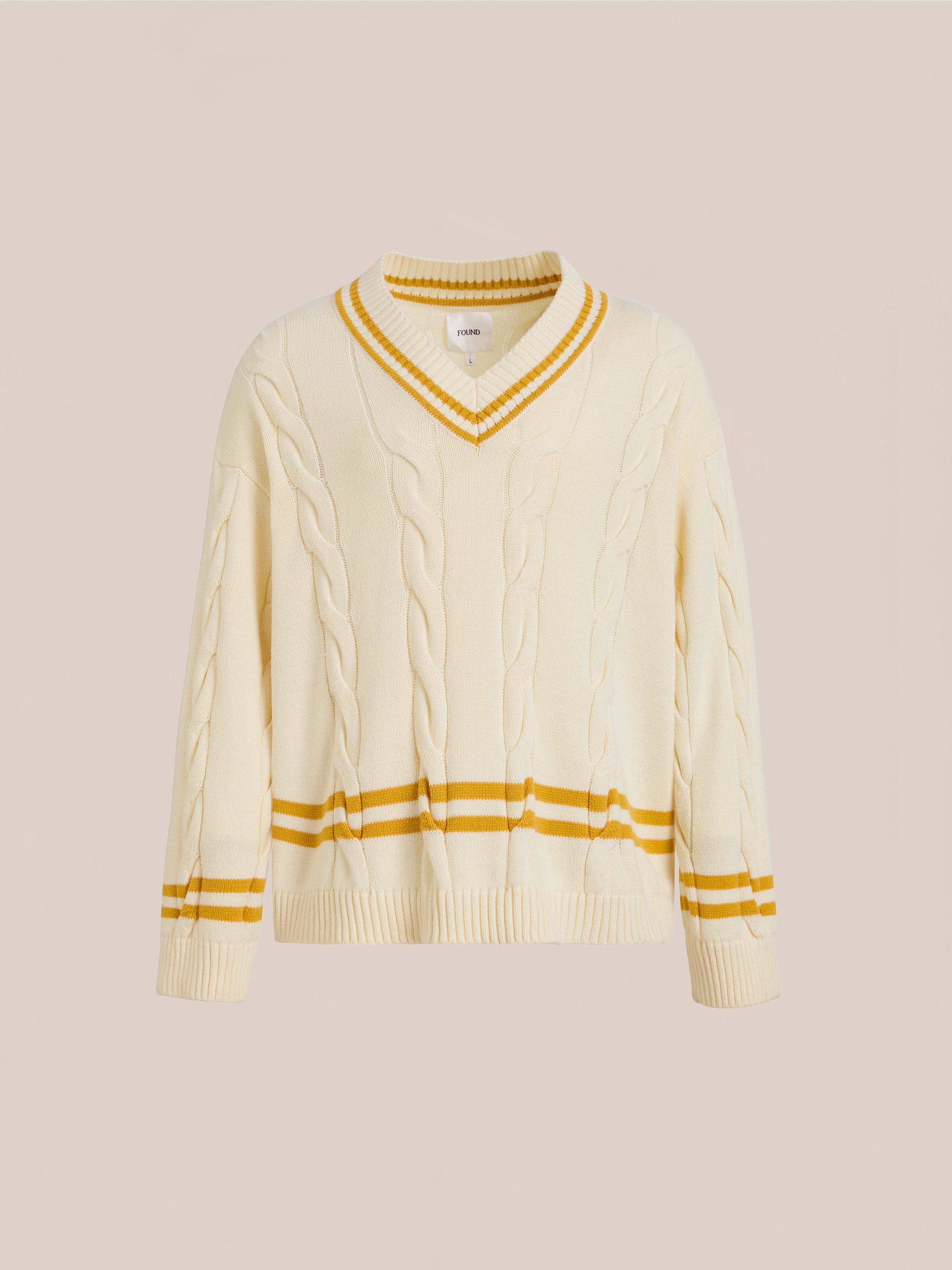 The FOUND V-Neck Cricket Sweater is a unisex cable knit design with yellow stripes on the collar, cuffs, and hem, featuring a classic cricket sweater look.