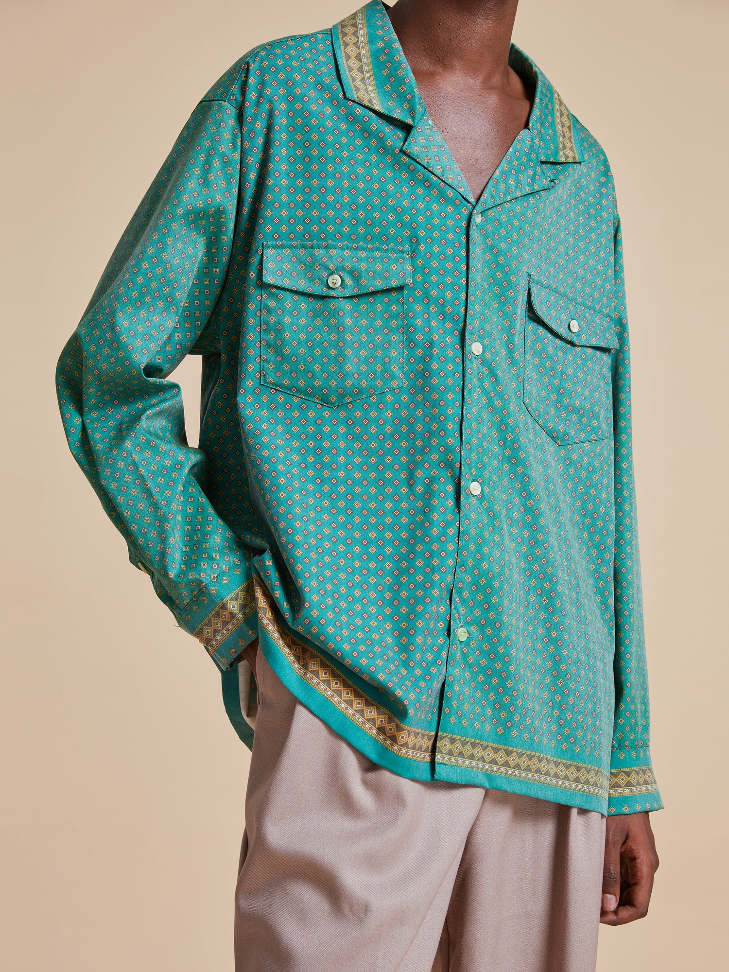 A man wearing the Found Arbor Long Sleeve Camp Shirt with traditional Indo-Aryan patterns and khaki pants.