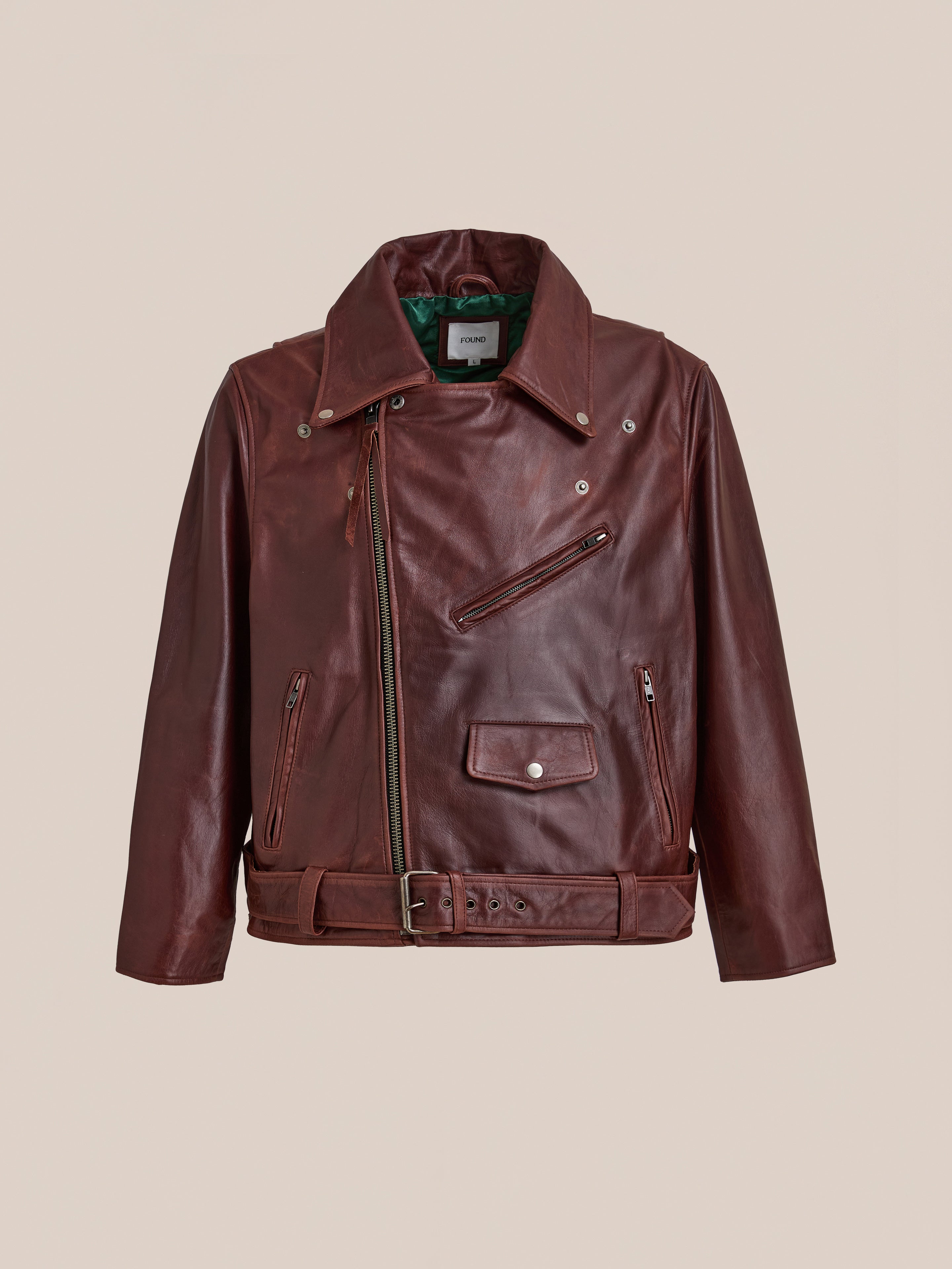 The FOUND Leather Biker Jacket features distressed leather, an asymmetrical front zipper, notched collar, zippered pockets, and a belted waist, shown against a neutral background.