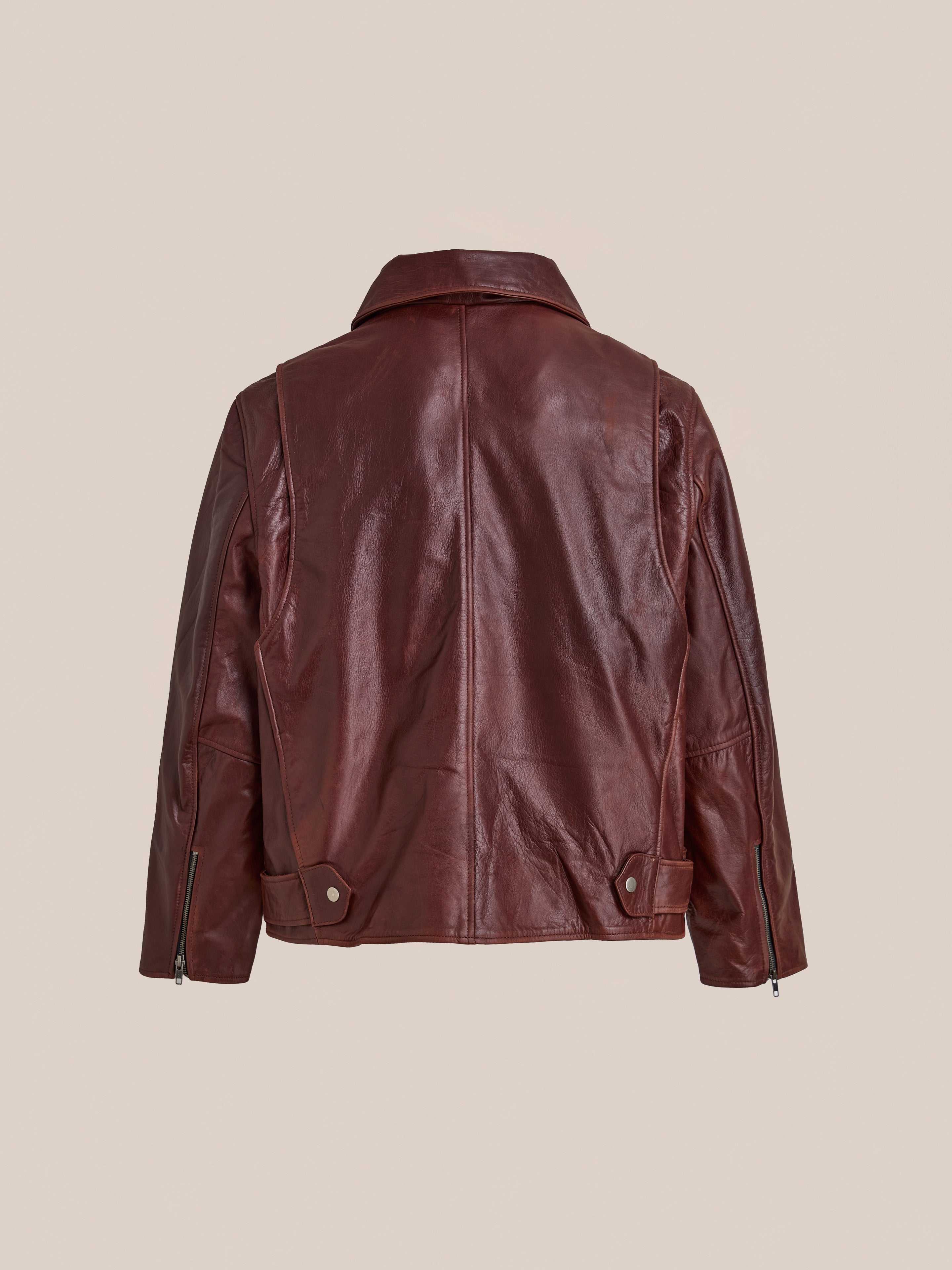 Back view of the FOUND Leather Biker Jacket in brown distressed leather, featuring long sleeves, a collar, adjustable waist tabs, and unisex moto styling against a neutral background.