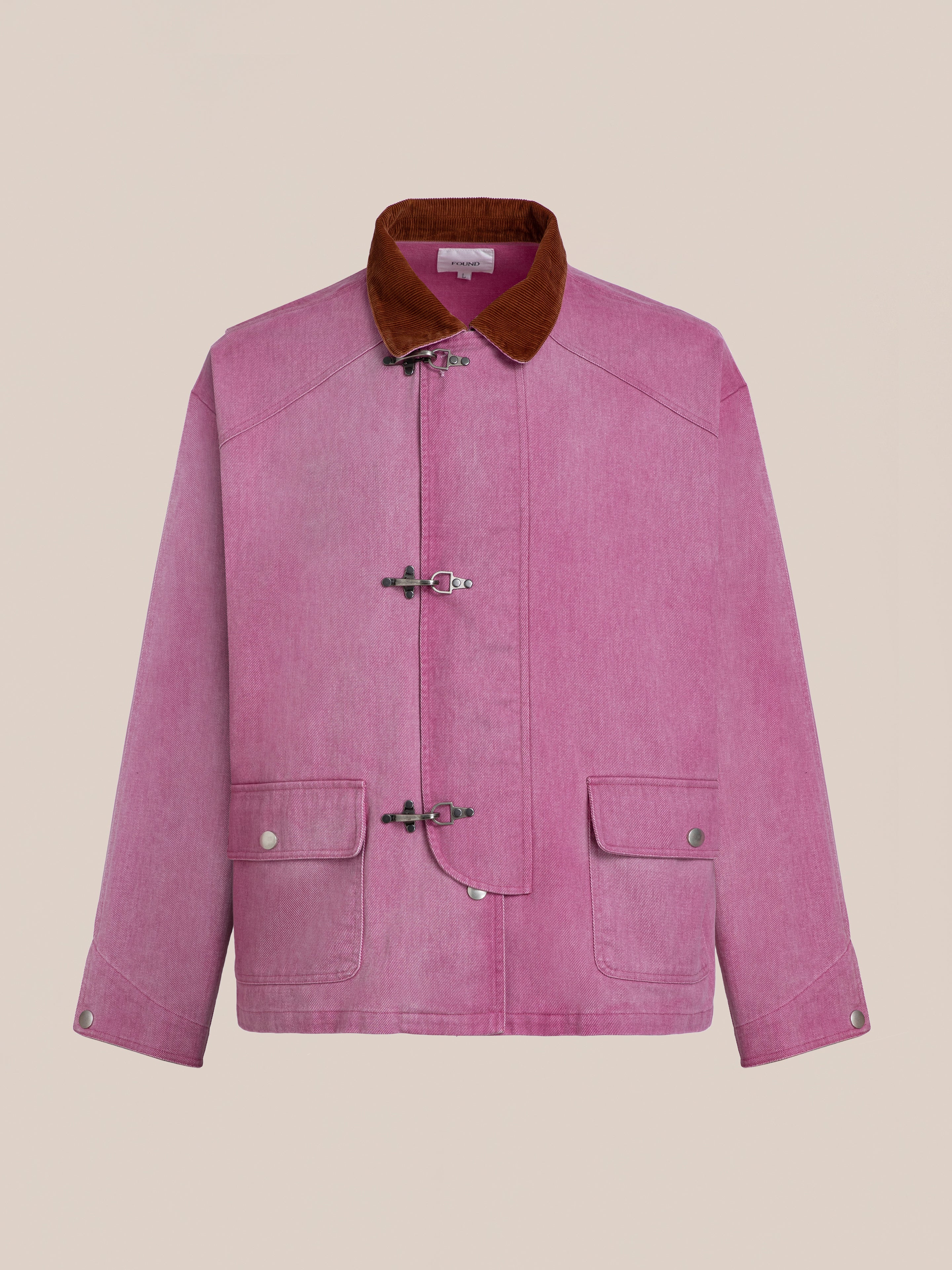 The Found Washed Fireman Clasp Workshop Jacket is a pink unisex piece with a brown corduroy collar, toggle closures, and two front flap pockets, inspired by vintage fireman jackets and shown against a plain background.