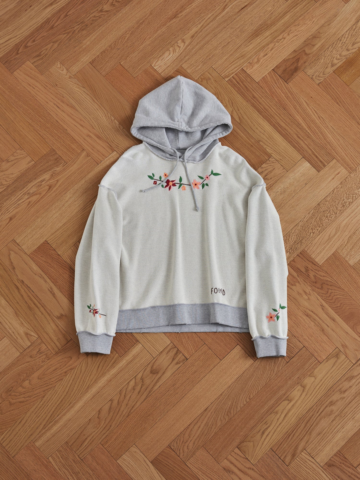 A Found Inverse Flower Petal Hoodie with embroidered flowers on it, made from french terry fabric.