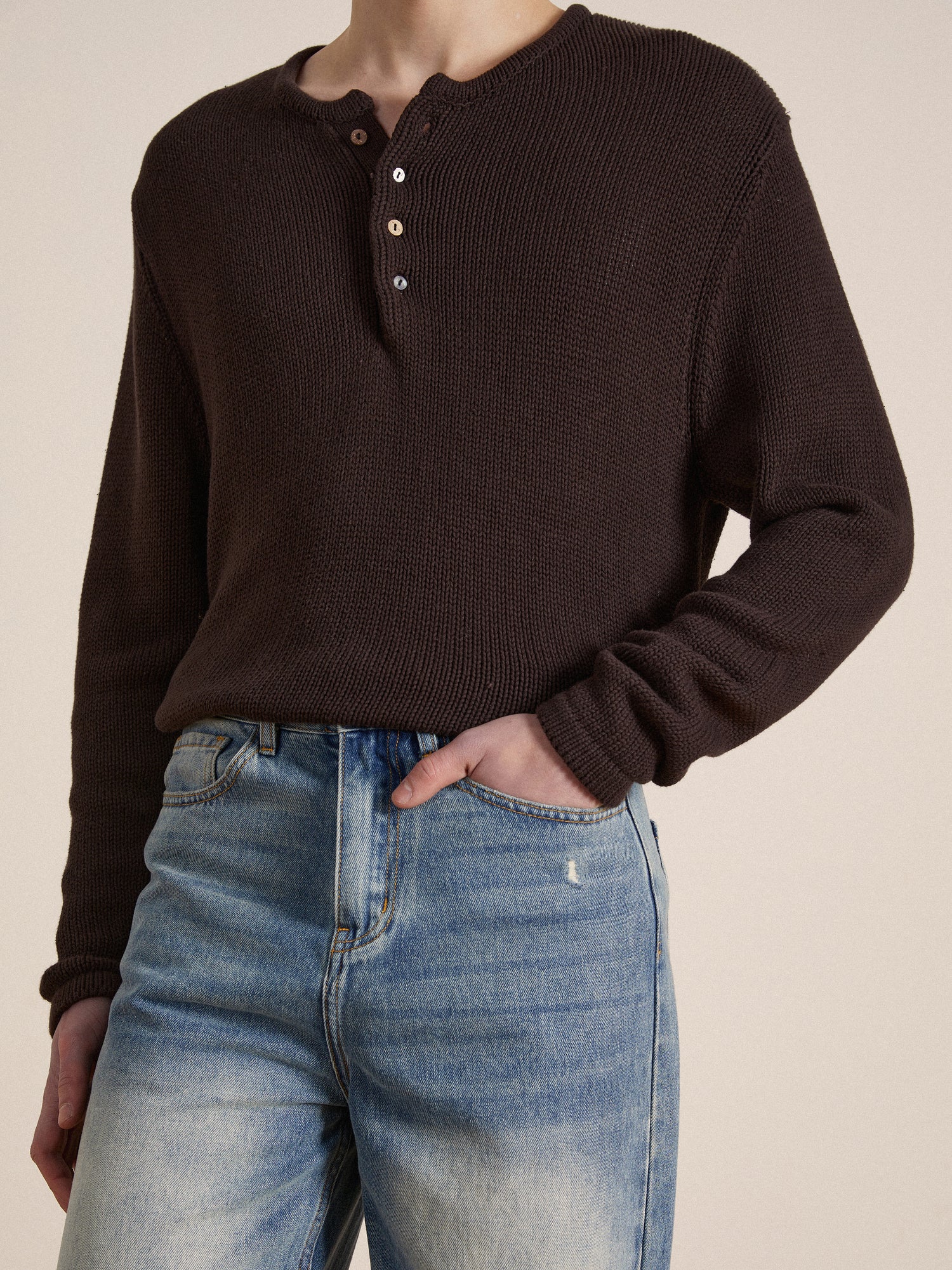 The model is wearing a Profound premium cotton Knit Henley brown sweater and jeans.