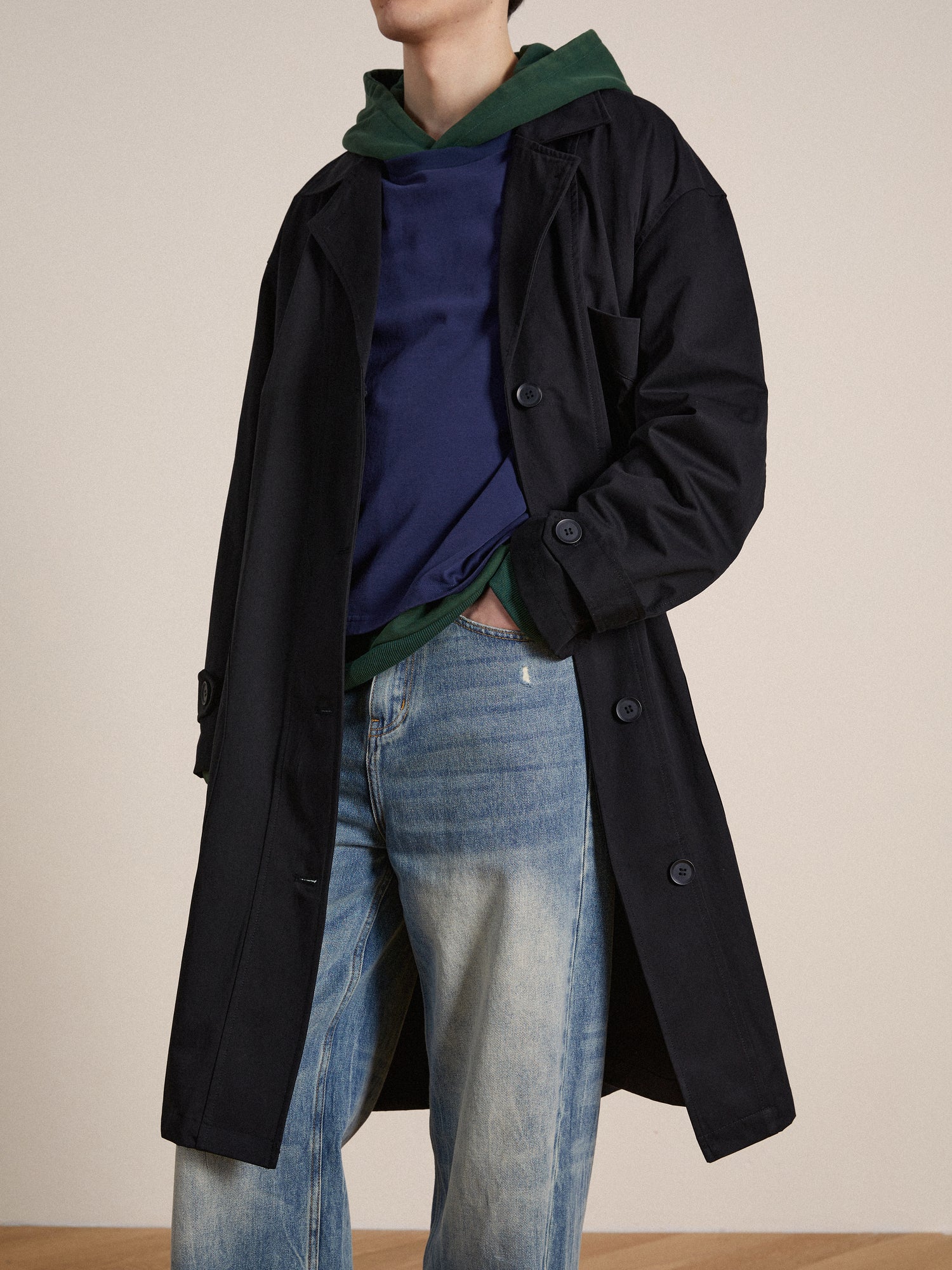 A model wearing a Found naval trench coat and jeans, embodying enduring sophistication.
