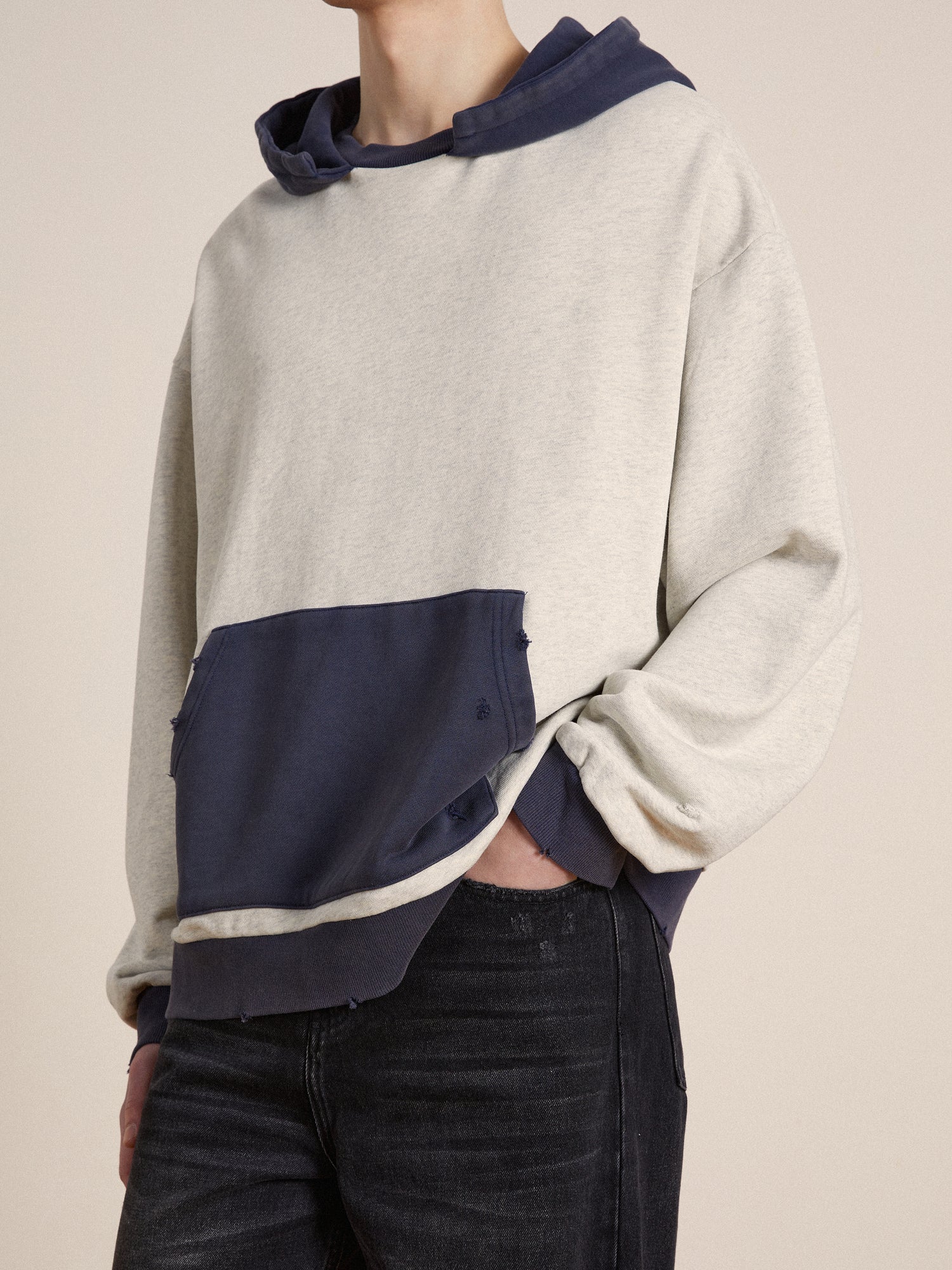 The model is wearing a Found two-tone hoodie with vintage nostalgia.