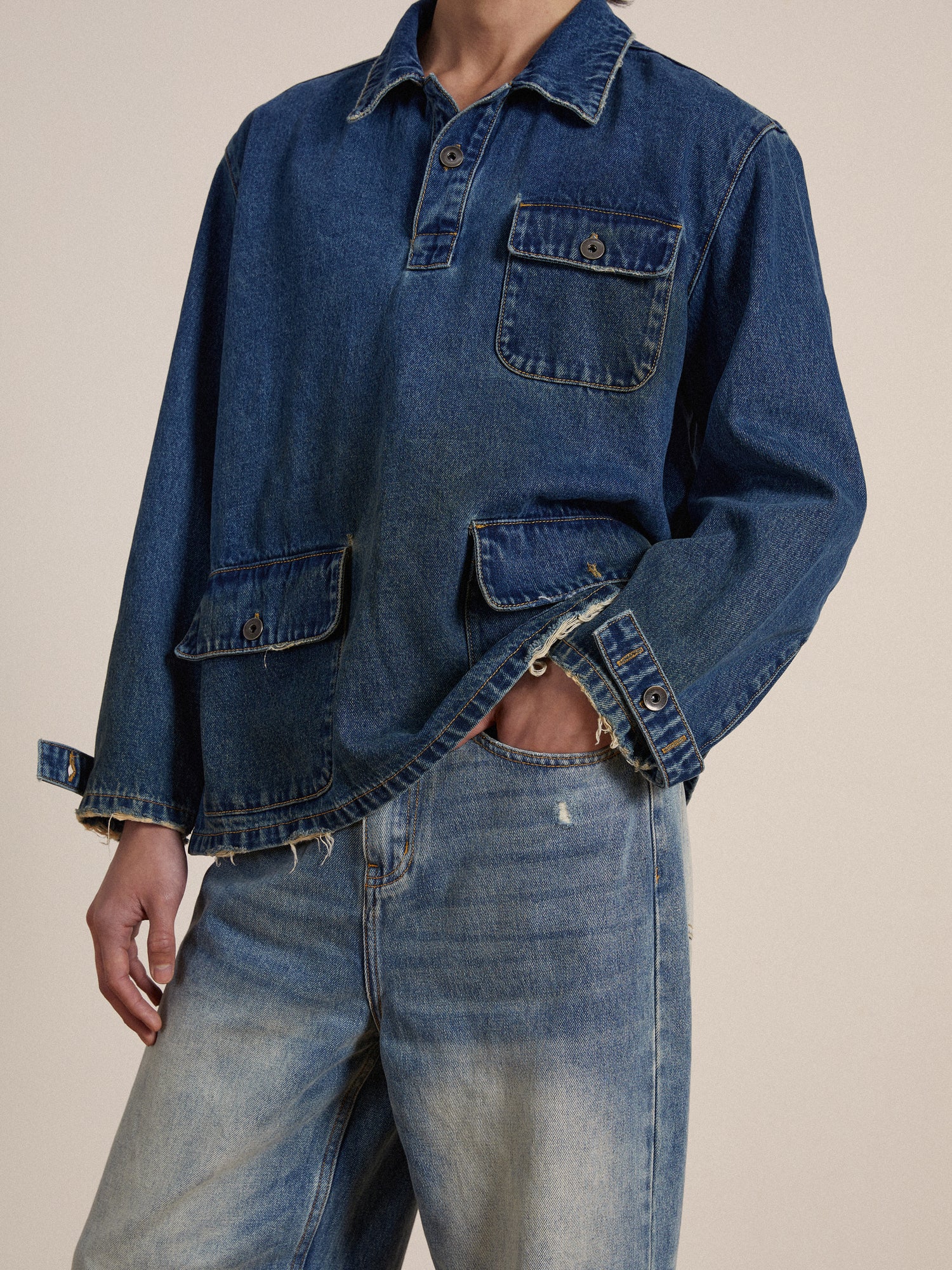 A person wearing a Azin Denim Pullover Work Shirt pullover work shirt and jeans made from premium denim fabric, with a focus on the textured details of the fabric.