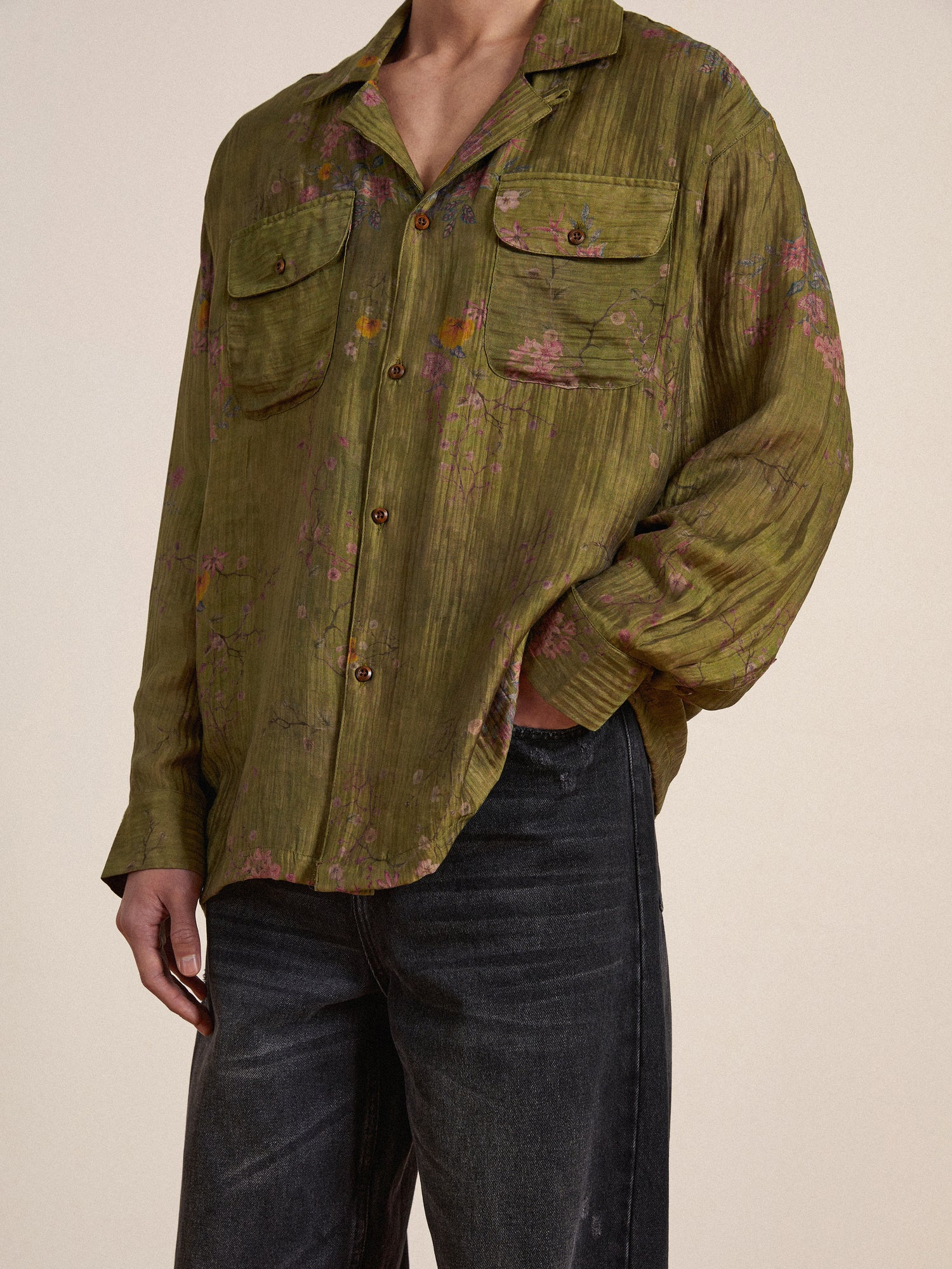 A man wearing a Found Floral Moss Long Sleeve Camp Shirt and jeans.
