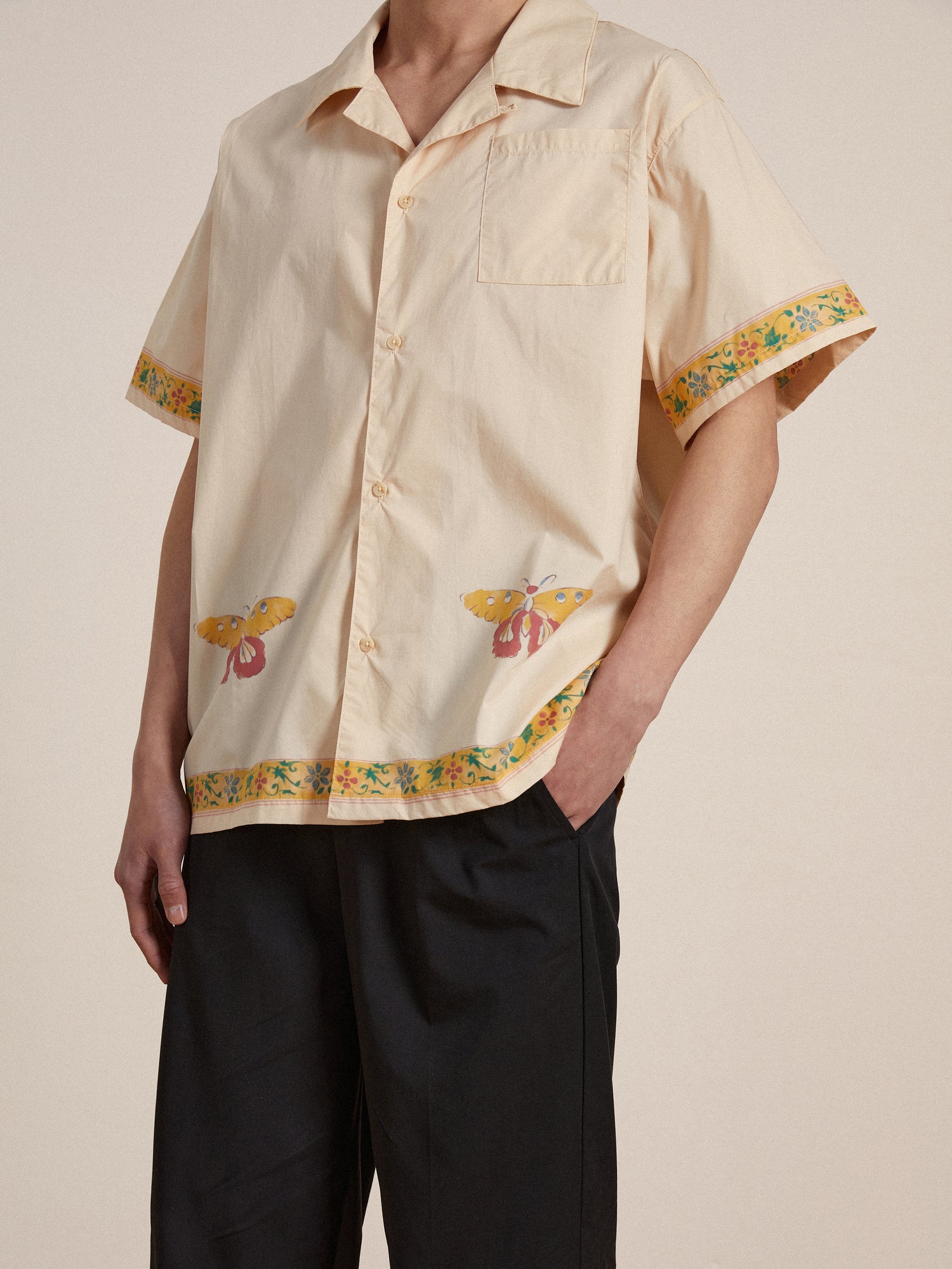 A man wearing a Found moth camp shirt with phulkari motifs.