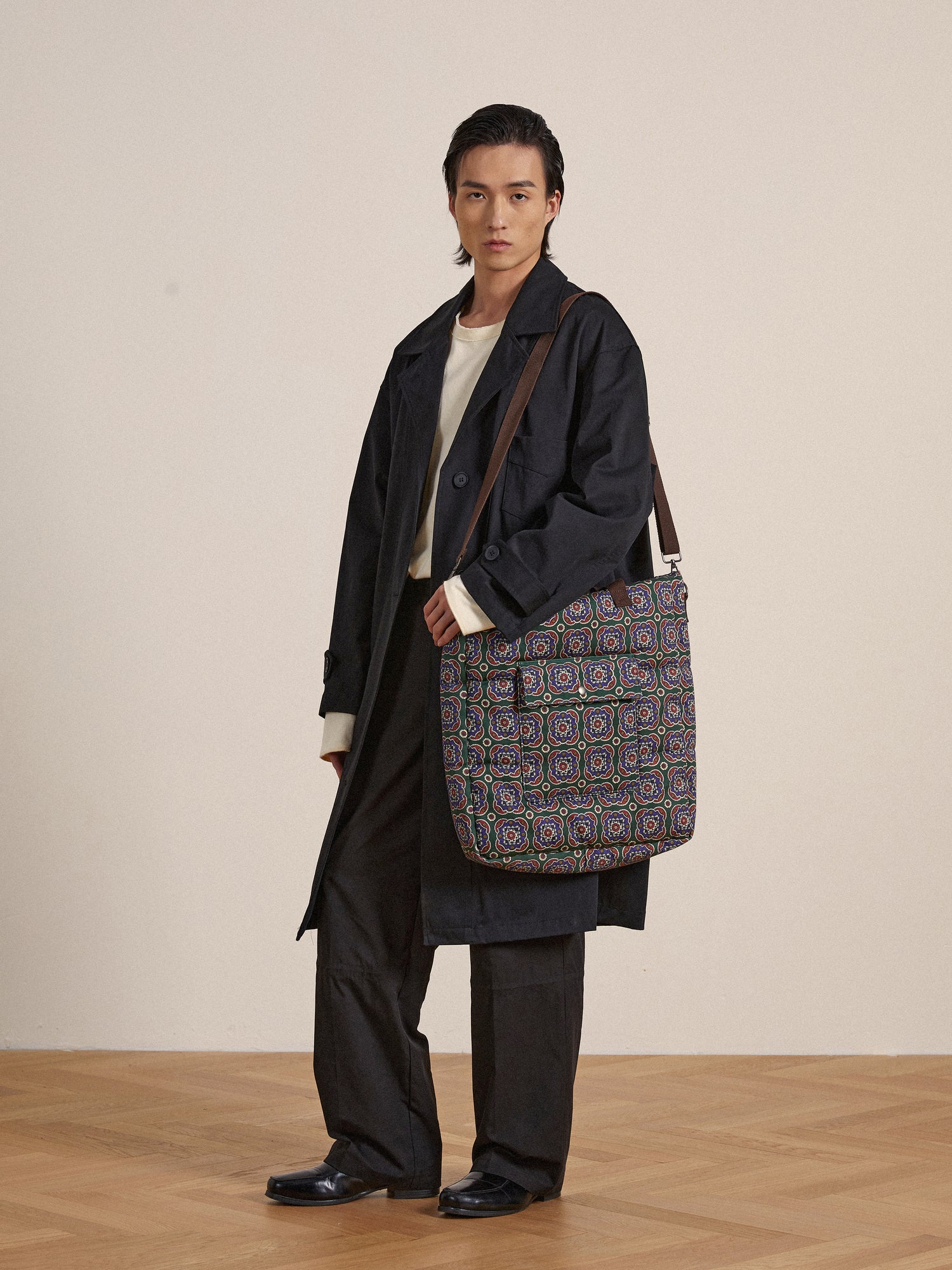 A woman wearing a trench coat and a Profound Pine Mosaic bag.