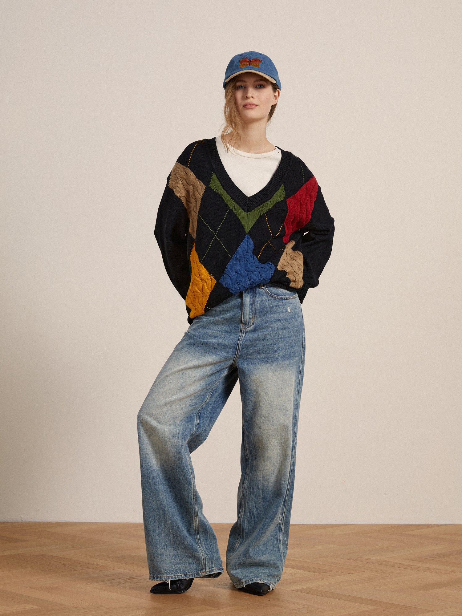 A woman wearing a Found Argyle Sweater and jeans.