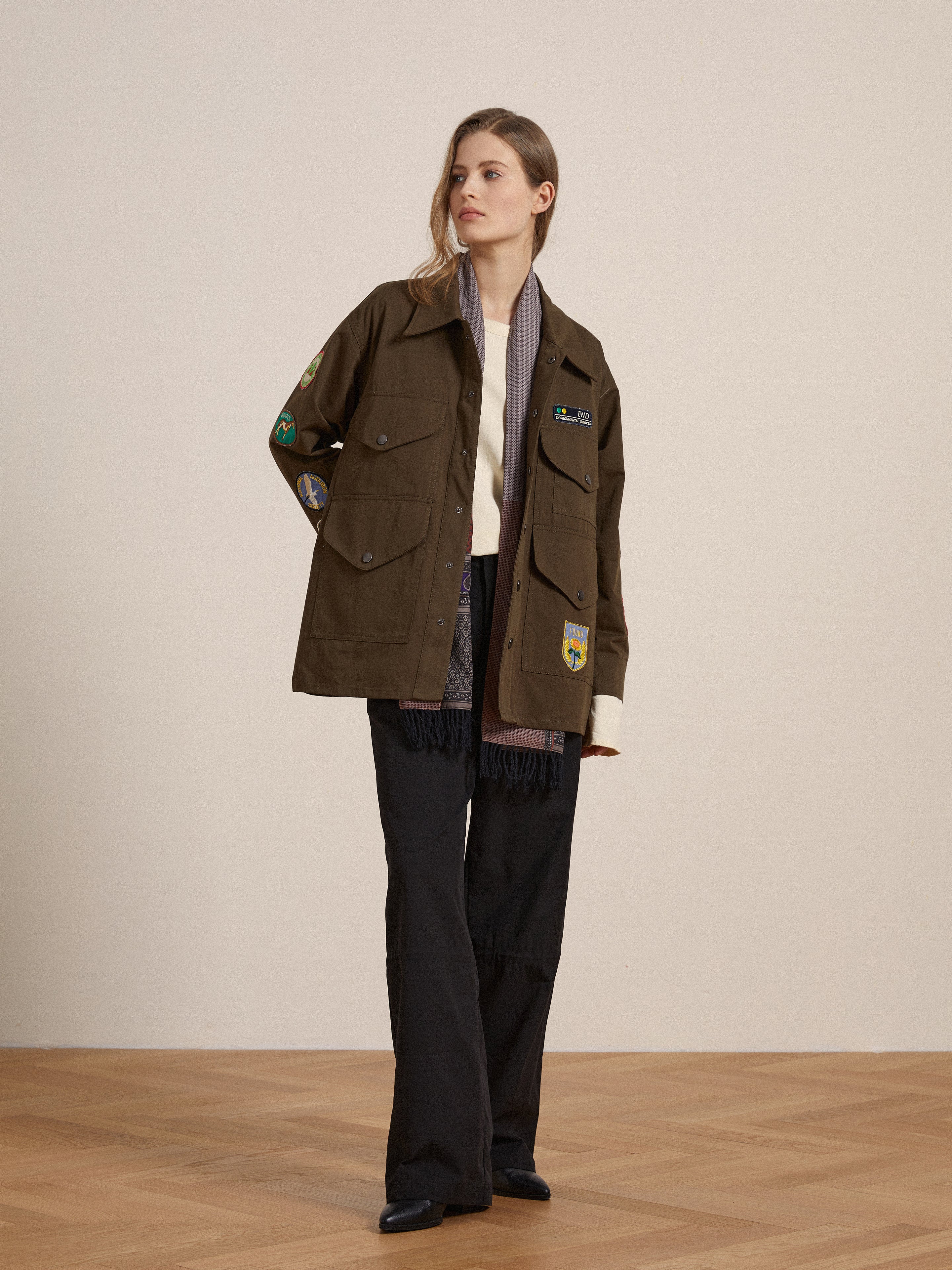 A woman wearing a vintage-inspired Found Ports Park Multi Patch Work Jacket and pants.