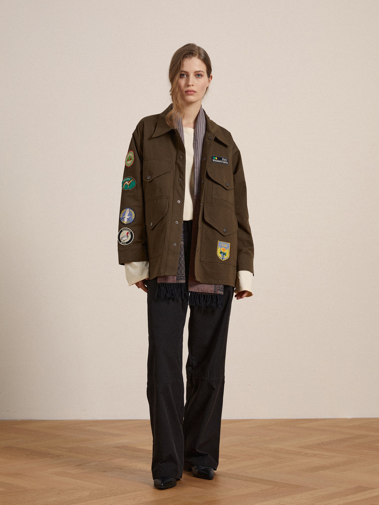 A woman wearing a vintage-inspired Found Ports Park Multi Patch Work Jacket and pants.