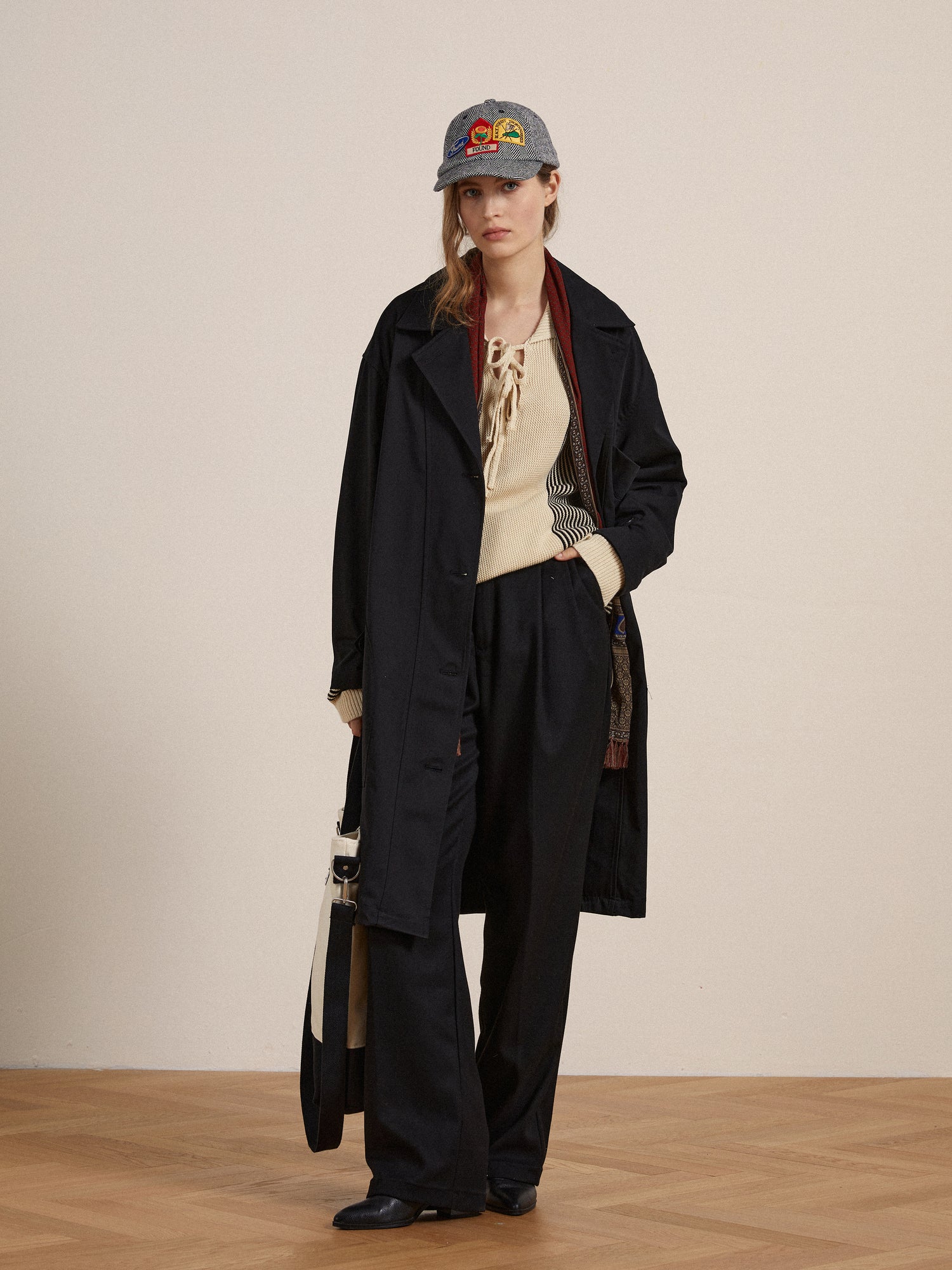 A woman wearing a Found Naval Trench Coat and hat, embodying enduring sophistication.