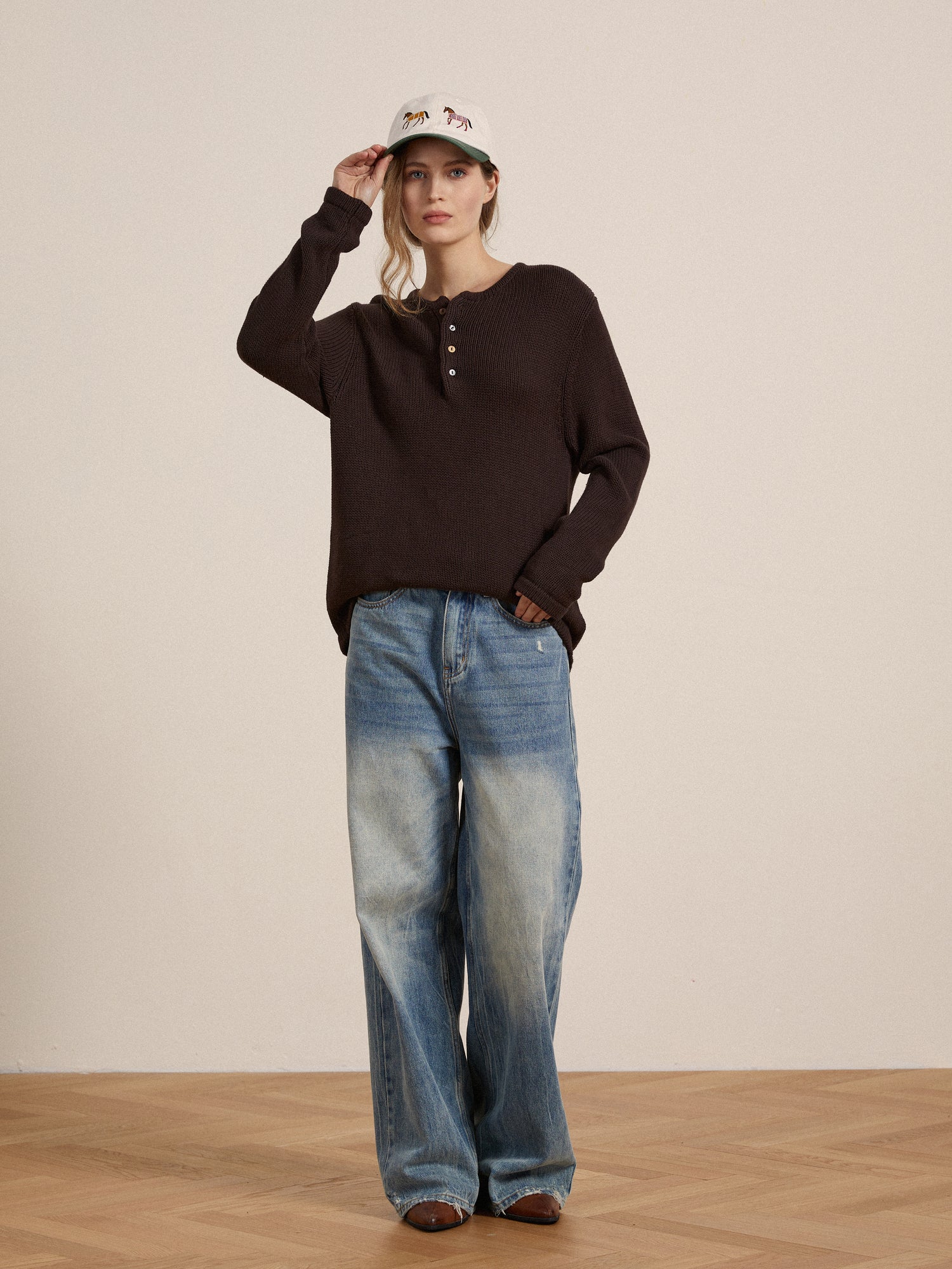 A woman wearing jeans and a Profound Knit Henley hat.