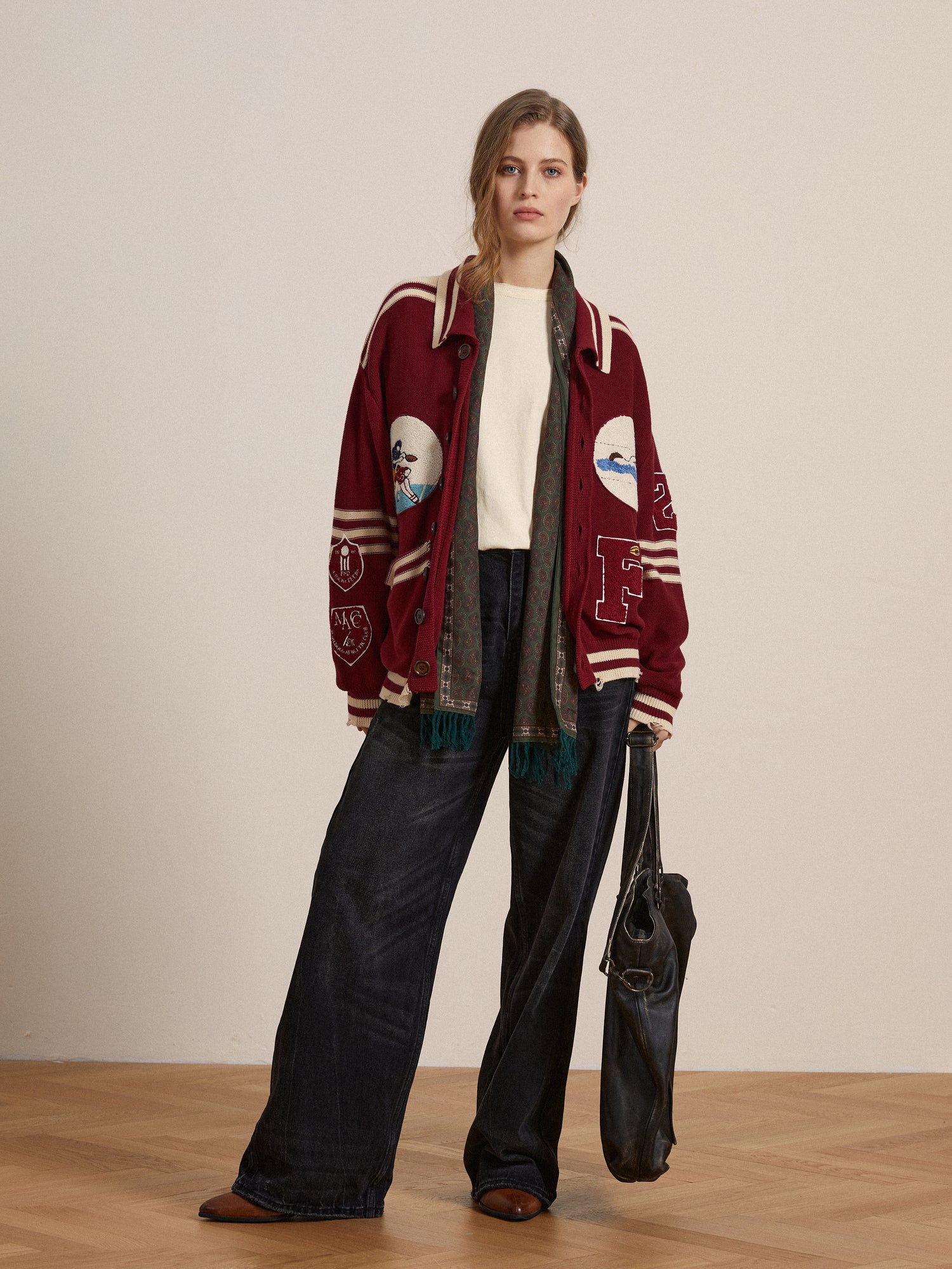 A woman wearing a burgundy embroidered jacket with Profound's Reversed LS Tee and wide-leg pants.