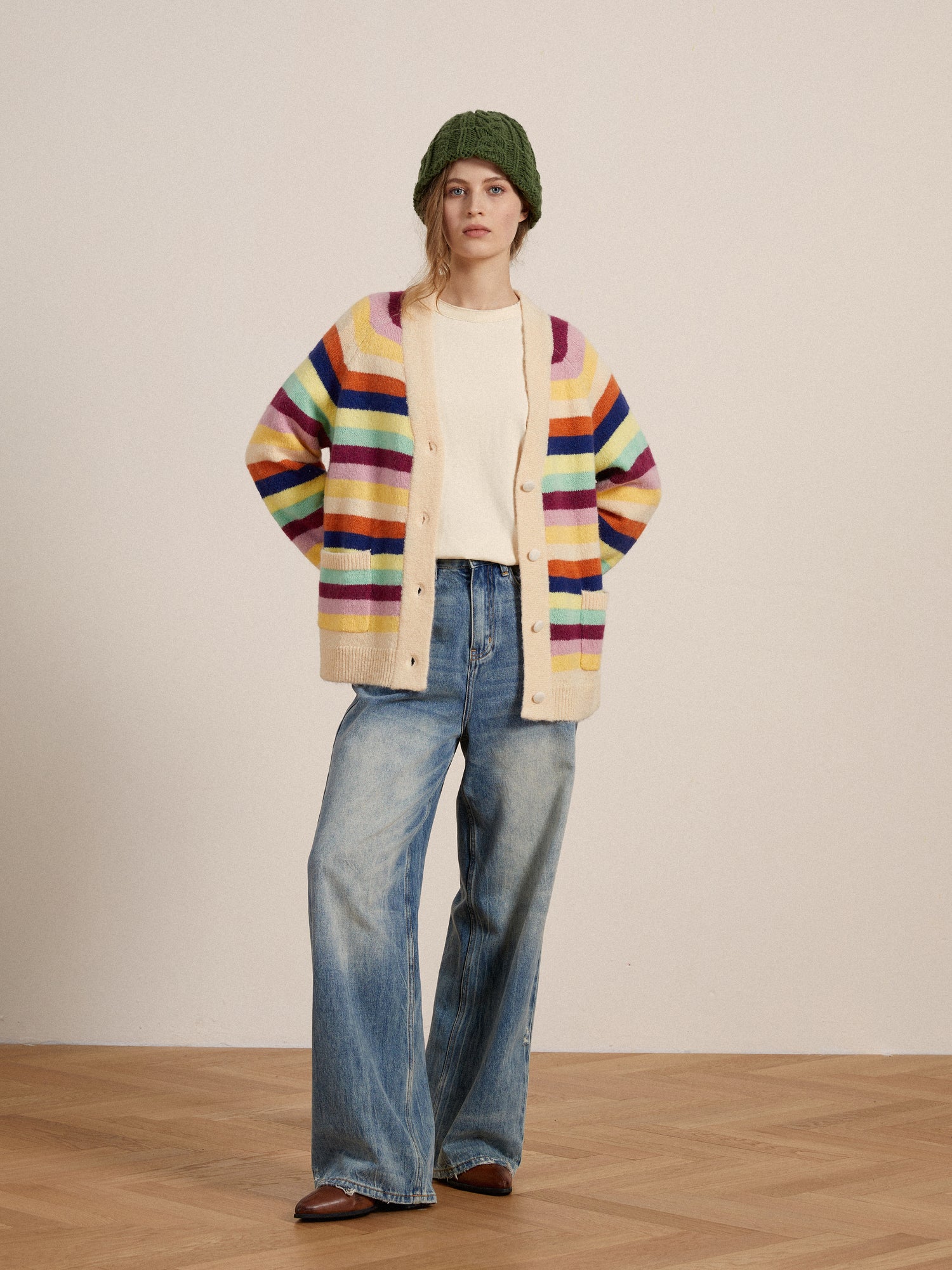 A woman wearing a vibrant hues Found Razi Multi Stripe Cardigan and jeans.