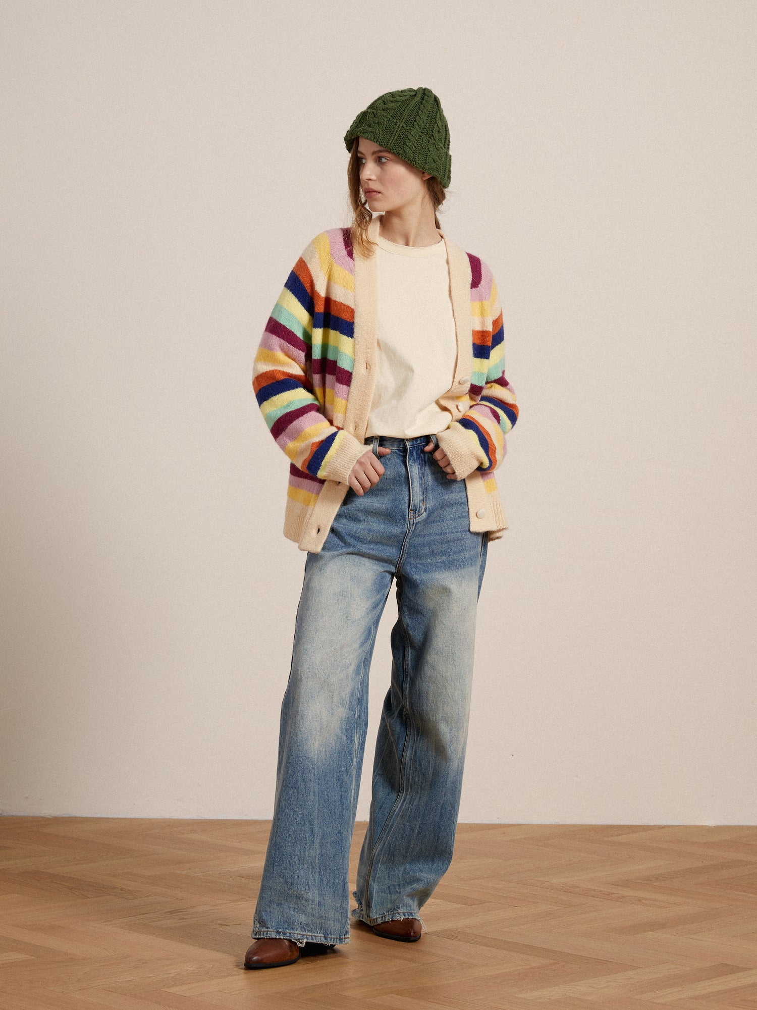 A woman wearing a vibrant-hued Found Razi Multi Stripe Cardigan and jeans.