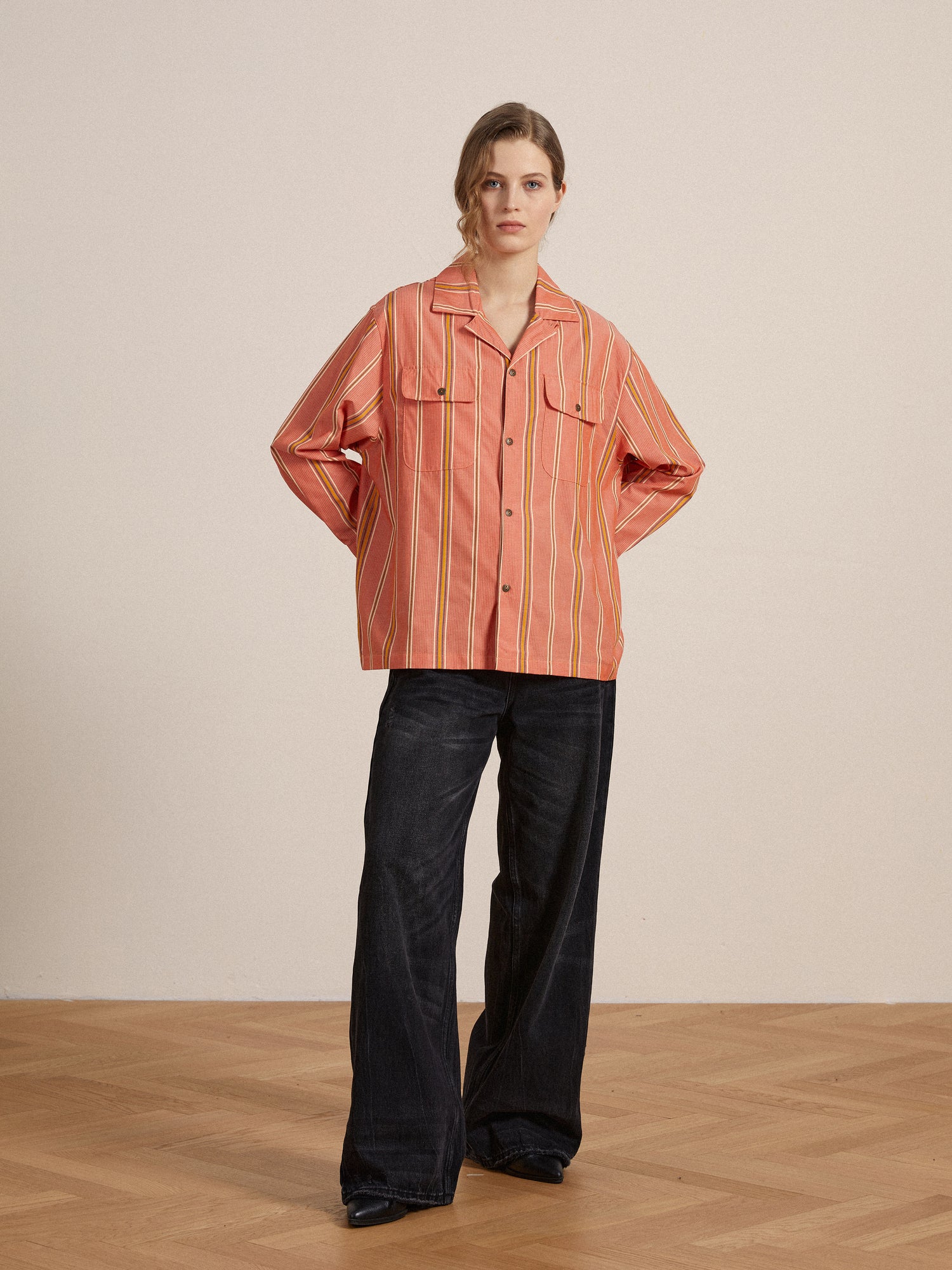 A model wearing a Found Stripe Citrus LS Camp Shirt offering a classic appeal and wide leg pants for a timeless silhouette.