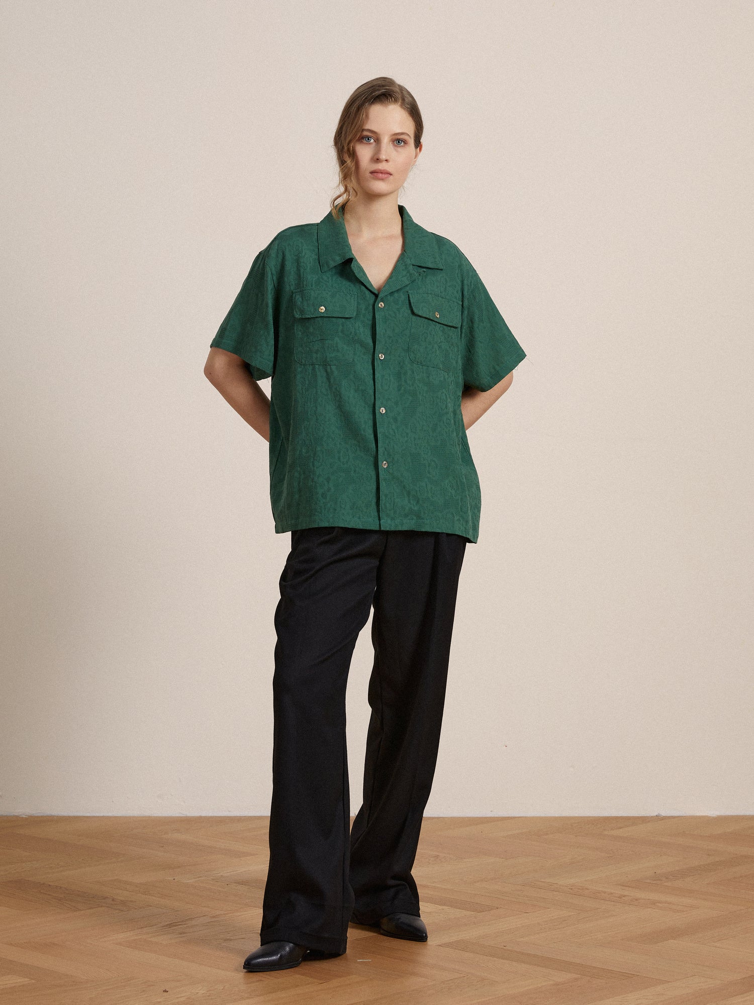 The model is wearing a Found Mount Camp Shirt in green and black trousers.