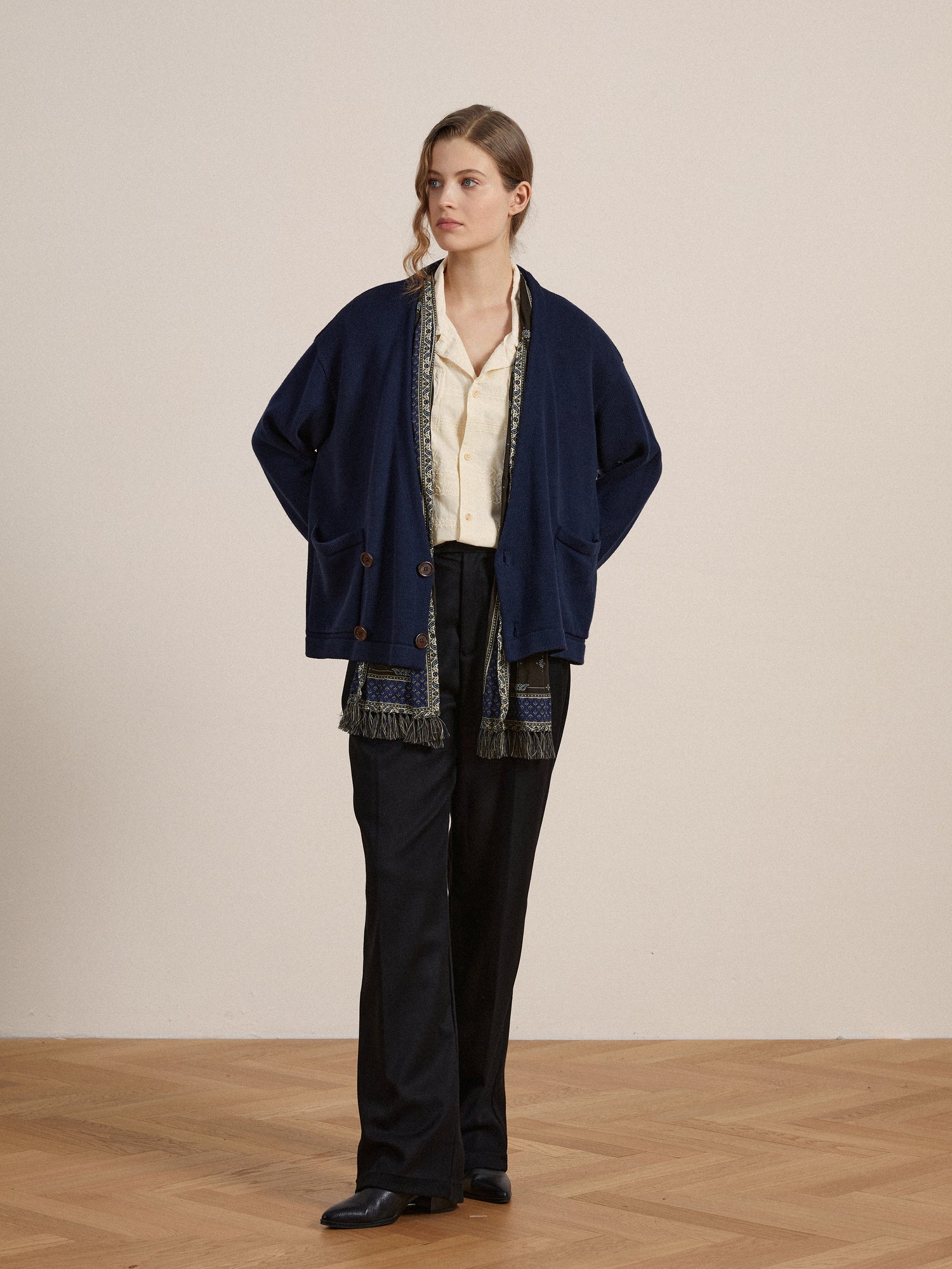 The model is wearing a Found Larsi Double Breasted Knit Cardigan and black pants.