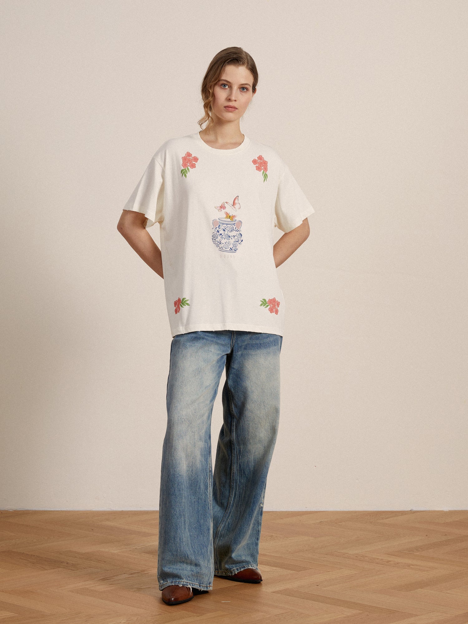 A woman wearing an embroidered Found Flower Pot Tee and lacy baggy jeans.
