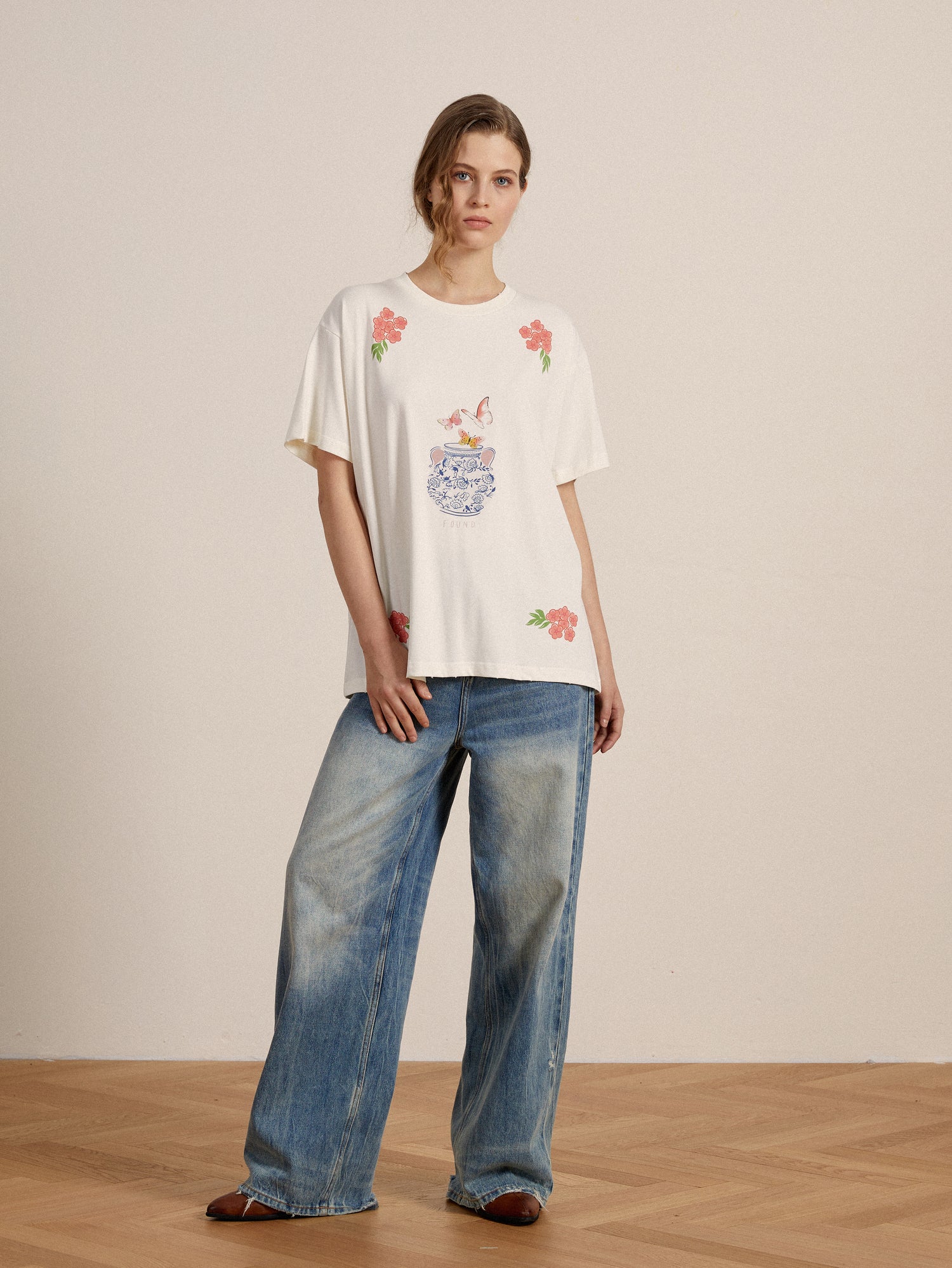 A woman wearing an embroidered Found Flower Pot Tee and jeans.
