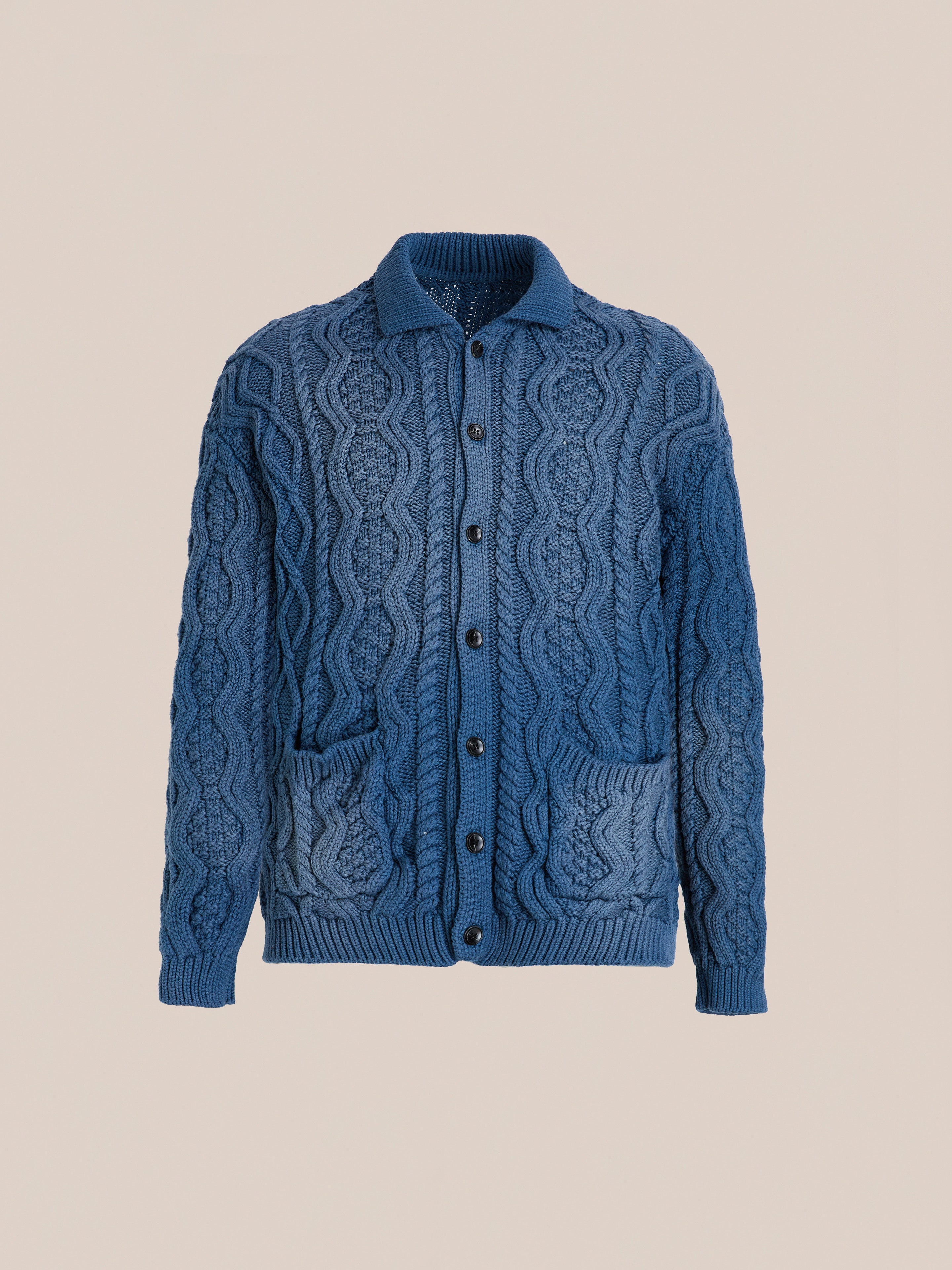 The Found Cable Knit Buttoned Cardigan features a navy color, front buttons, a collar, and two front pockets, shown against a plain beige background.