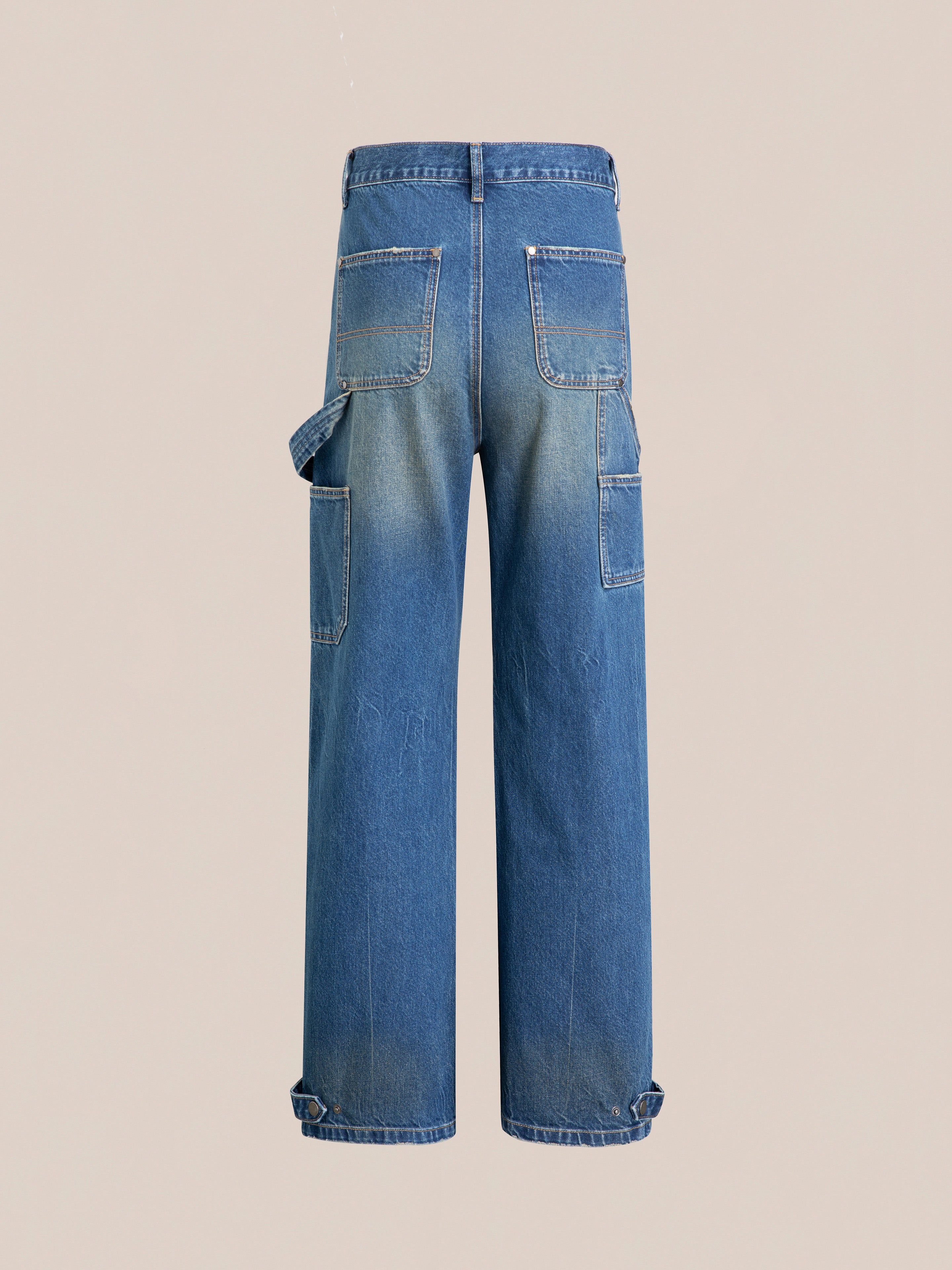 Check out the rear view of FOUND's Denim Carpenter Jeans in a vintage-inspired blue wash, showcasing multiple pockets and worn-in details.