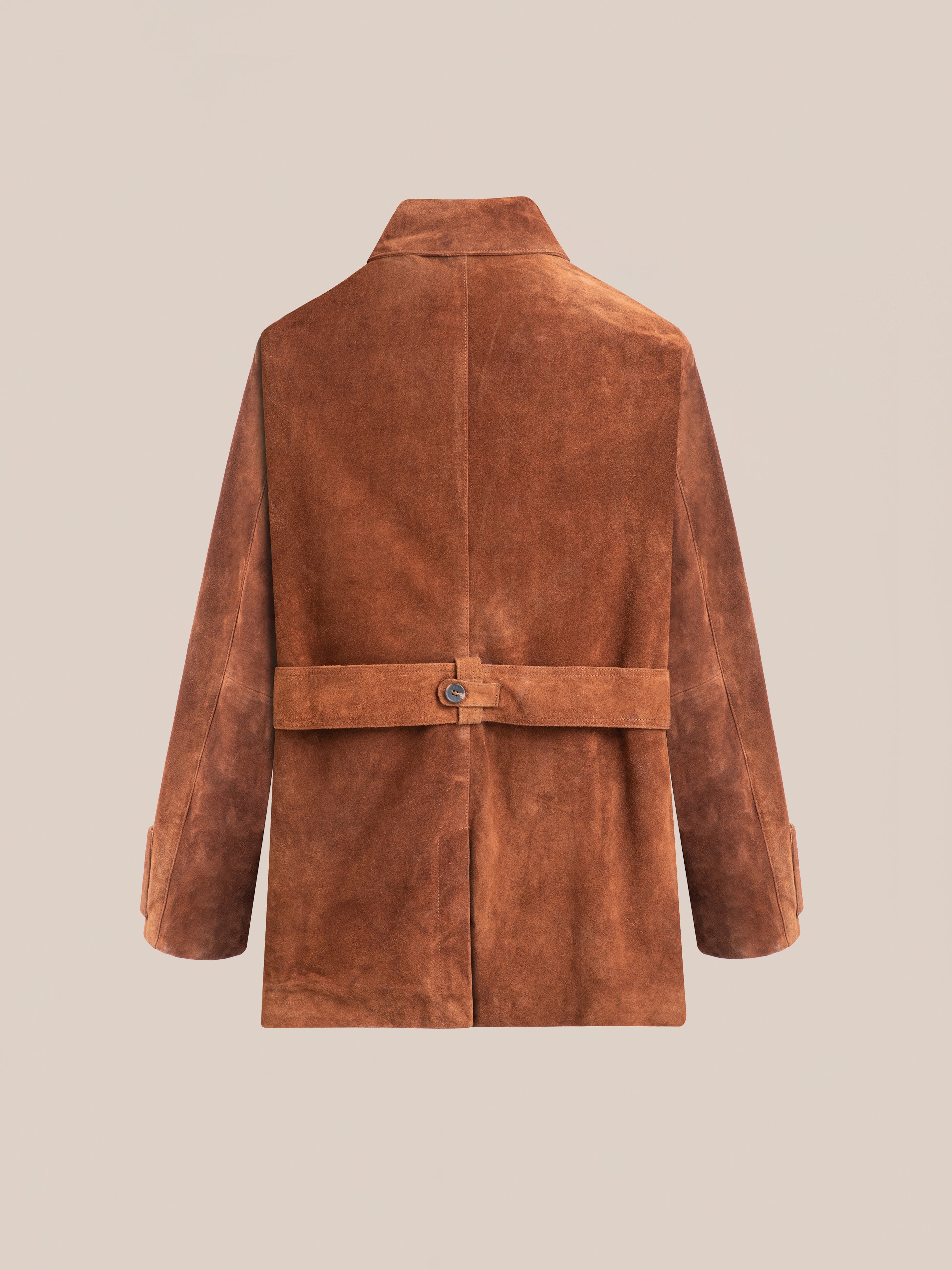 Against a beige backdrop, the Double Breasted Suede Leather Jacket by FOUND showcases a chic back belt. Its tailored drop shoulders and ethical production blend style with responsibility.