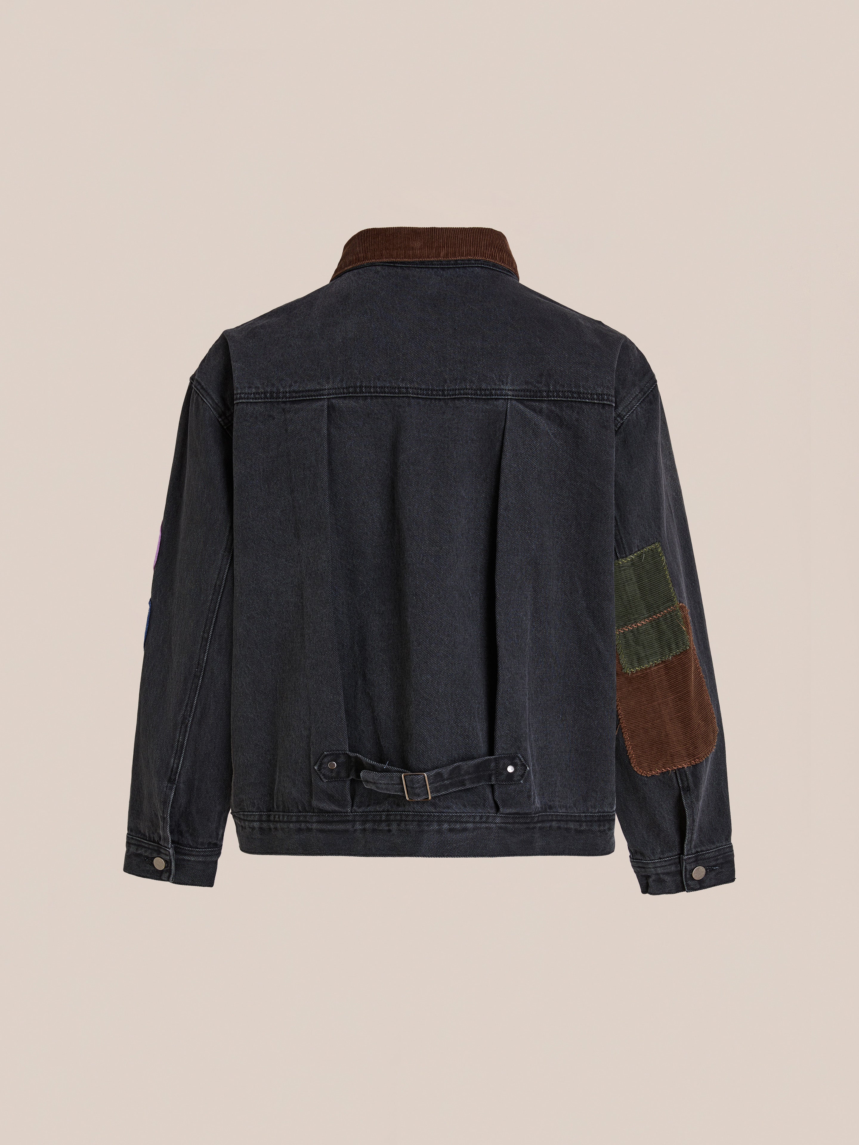 The FOUND Denim Patchwork Jacket features a corduroy collar and Americana patches on the right sleeve, displayed from the back against a plain beige background.