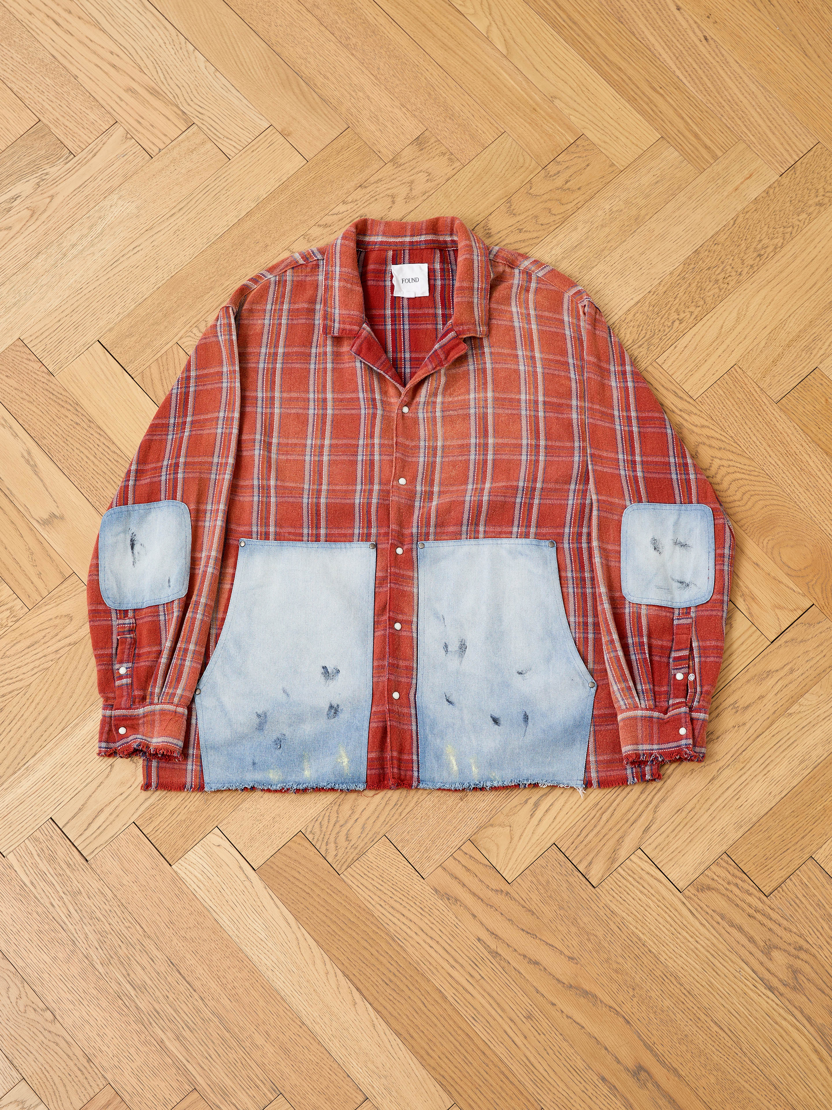 The FOUND Plaid Denim Shirt features red plaid fabric, denim carpenter pockets, and oversized faded cuffsâperfect for unisex workwear style.