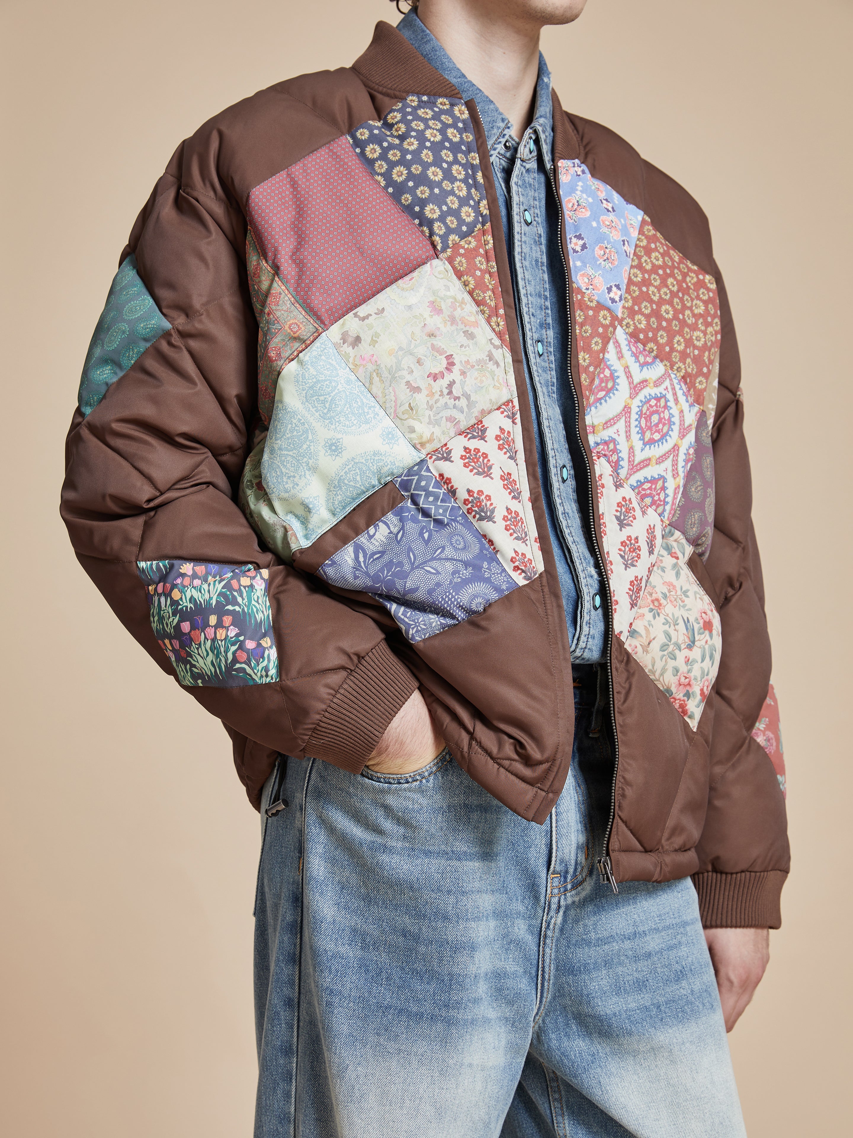 A man wearing a Found Diamond Quilt Patchwork Jacket and jeans.