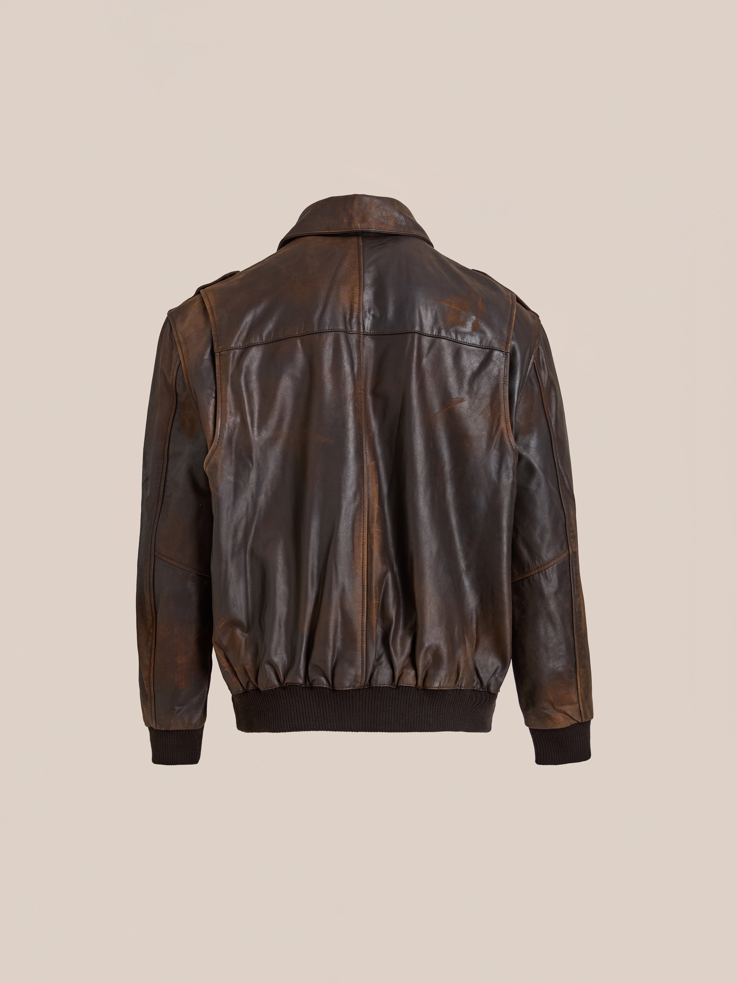 The FOUND Distressed Leather Flight Jacket in brown genuine leather features a back view with a collar, stitched detailing, and black ribbed cuffs and waistband.