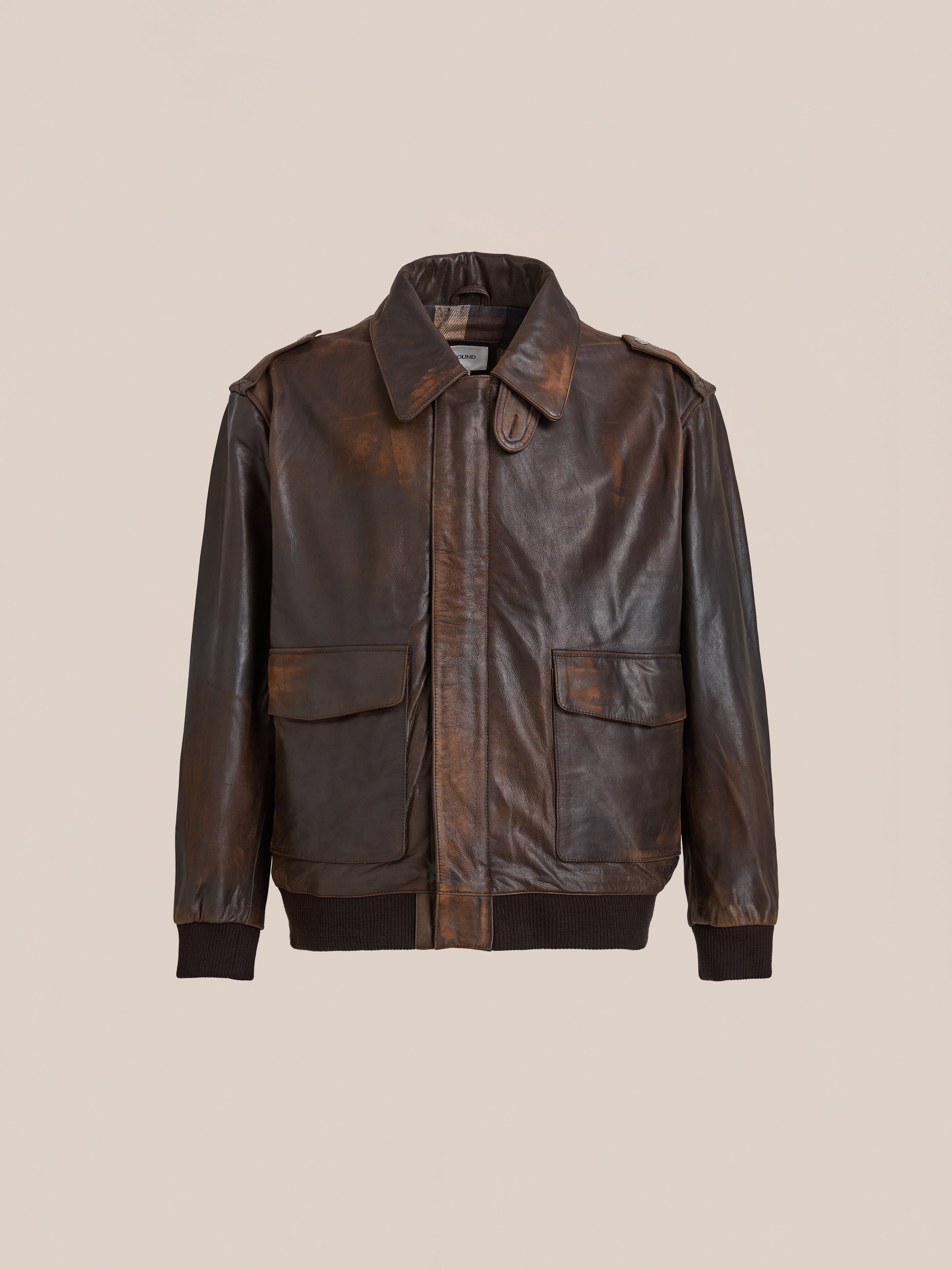 The FOUND Distressed Leather Flight Jacket in brown features a bomber style with a collar, front flap pockets, and ribbed cuffs and hem, shown against a plain beige background.