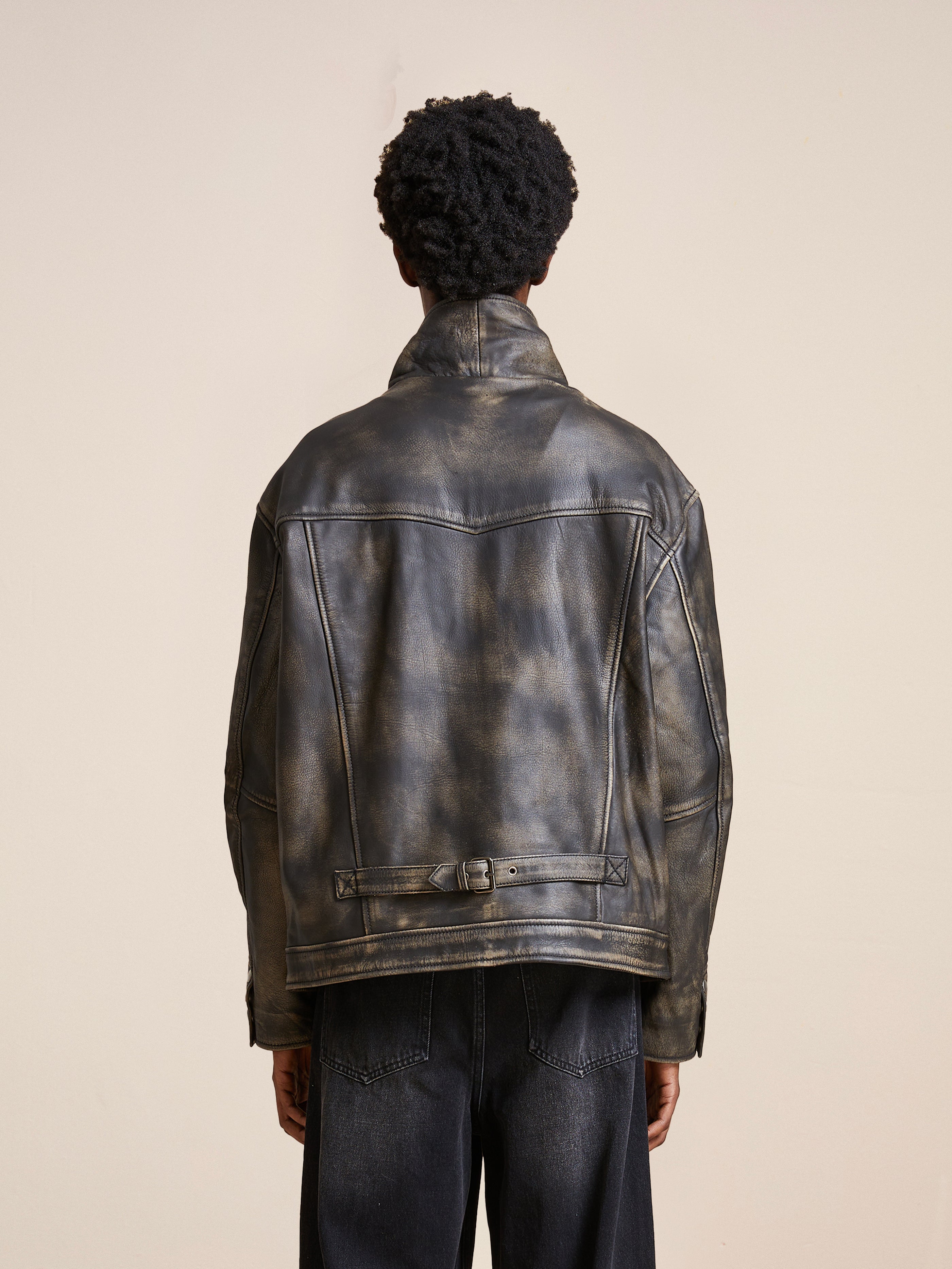Someone wearing a Distressed Leather Pocket Jacket by Found is seen from behind against a neutral background, with the jacket’s antique look adding character and depth.