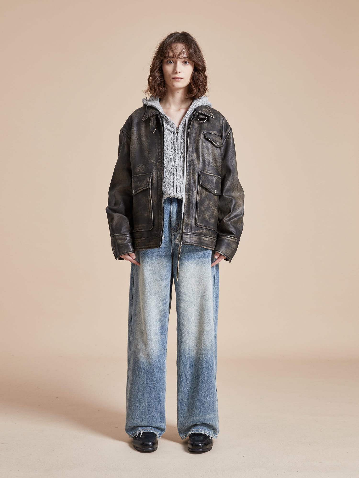 A model wearing a Found Distressed Leather Pocket Jacket and jeans.