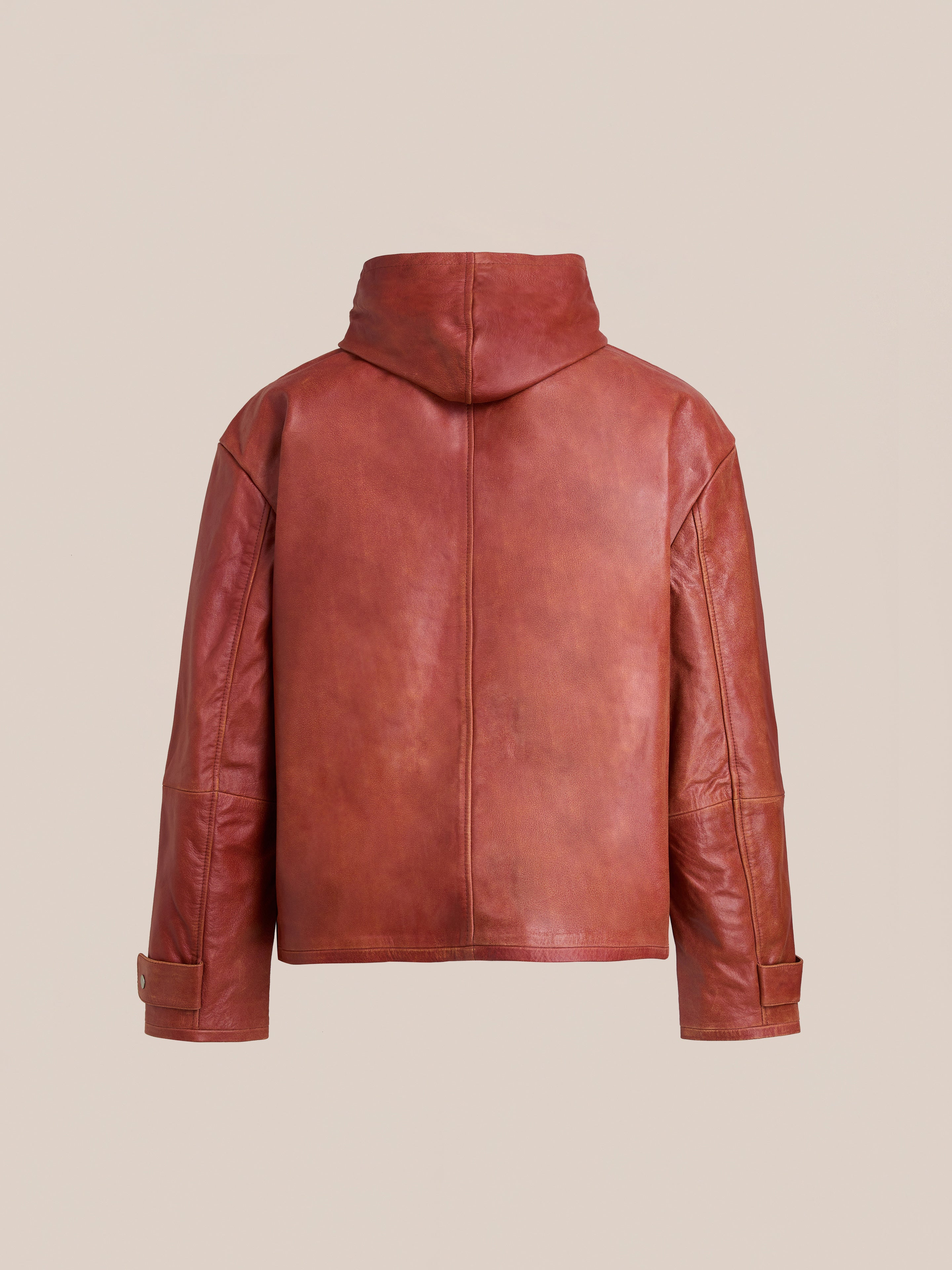 The FOUND Distressed Leather Pocket Hoodie is a vintage red cowhide jacket with hood, long sleeves, and adjustable cuffs. Shown from the back against a plain beige background.