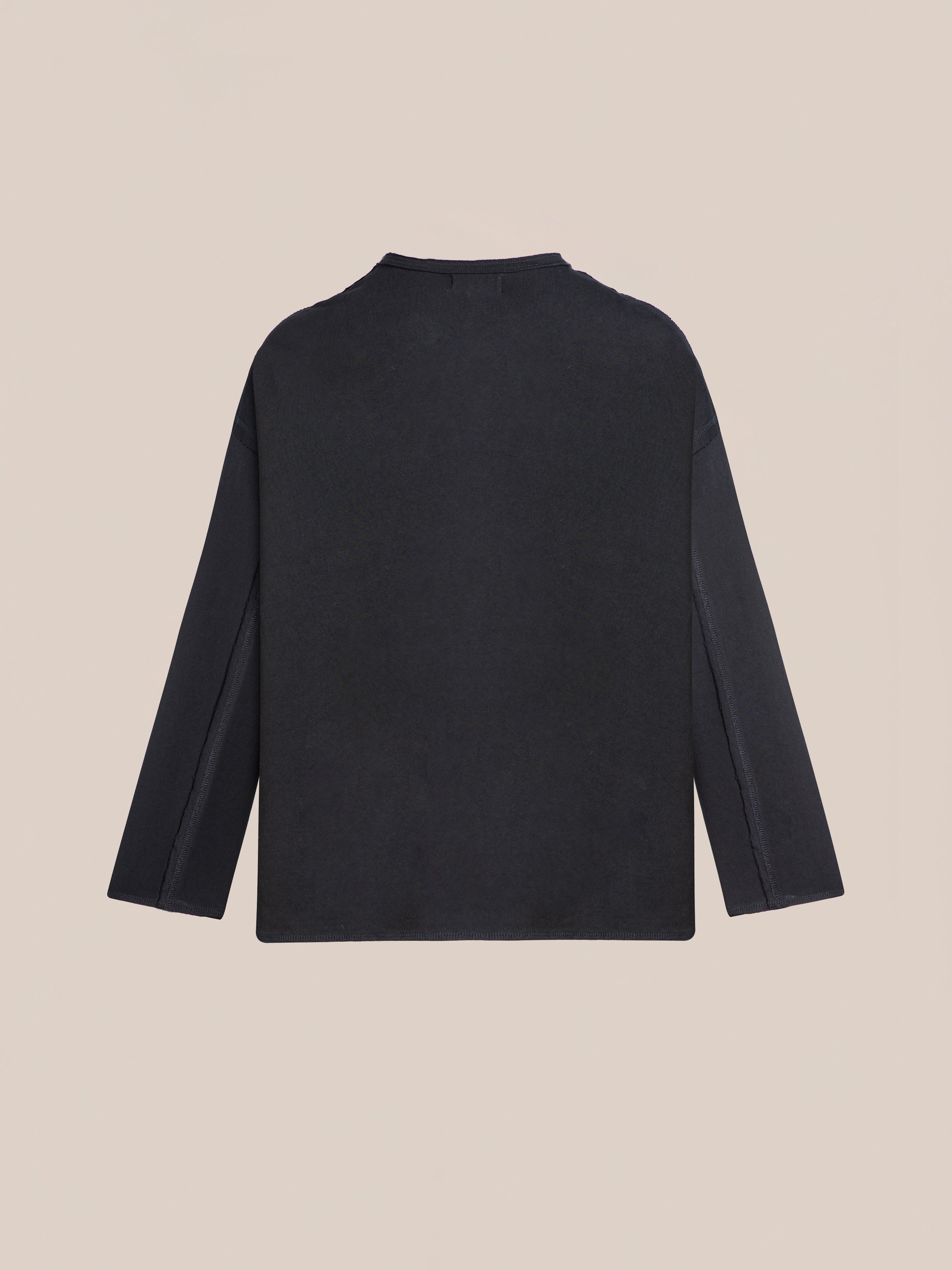 The FOUND Reversed LS Tee in plain black, featuring a relaxed fit, is displayed flat with the back side facing up against a neutral background.