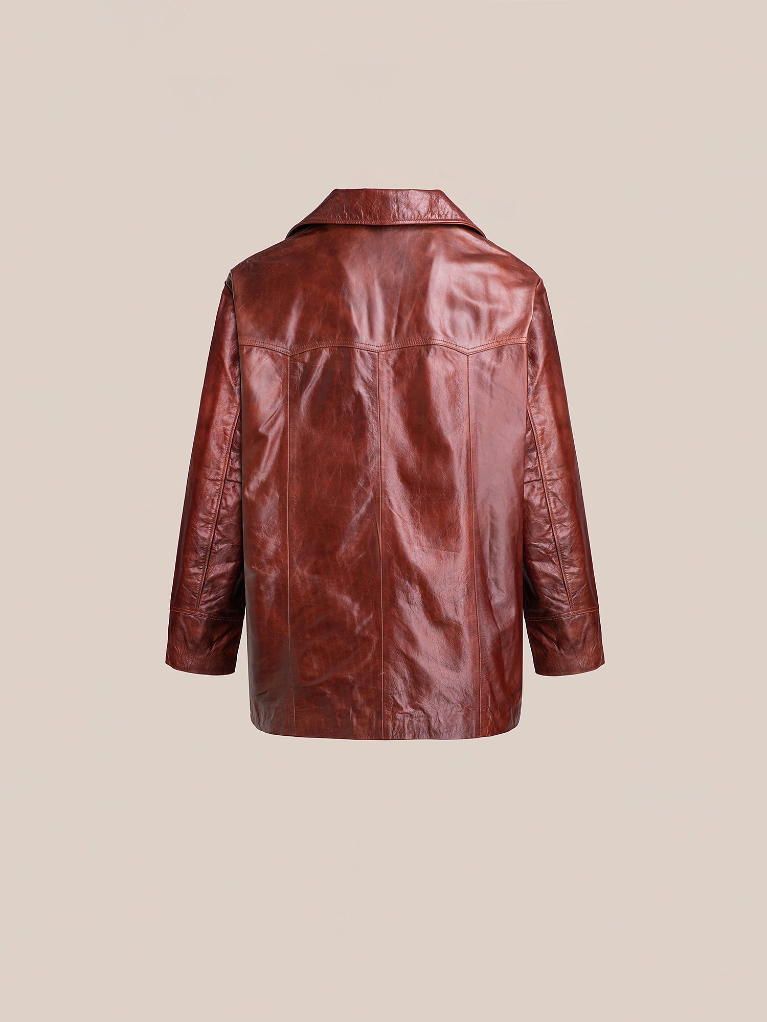 The FOUND Claret Western Oversized Leather Blazer, displayed against a beige background, highlights its long sleeves and classic collar. This unisex piece masterfully combines timeless style with modern flair.