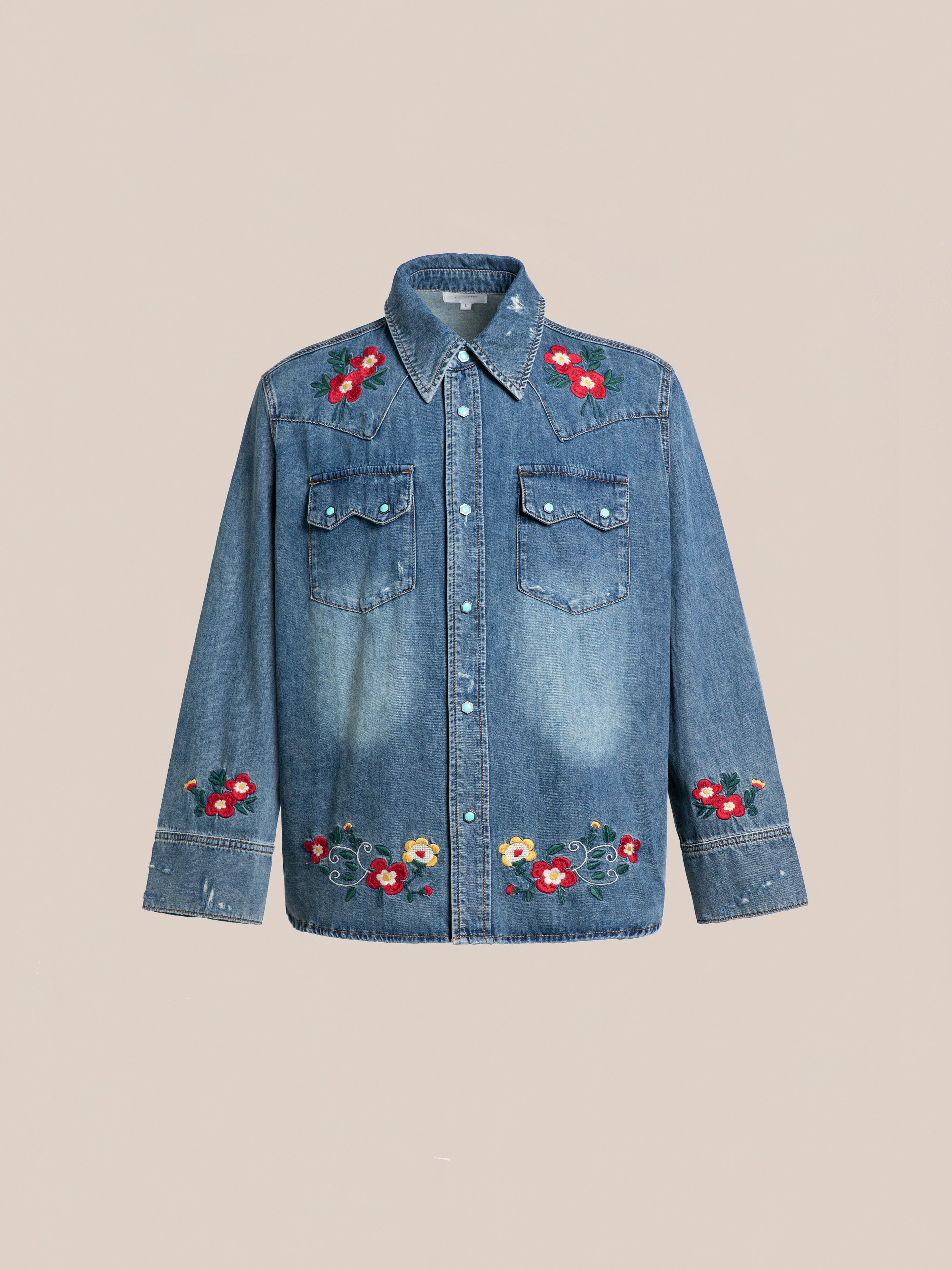 The FOUND Floral Embroidered Western Denim Shirt features front buttons, two chest pockets, and colorful floral embroidery on the shoulders, cuffs, and hem, shown against a plain background.
