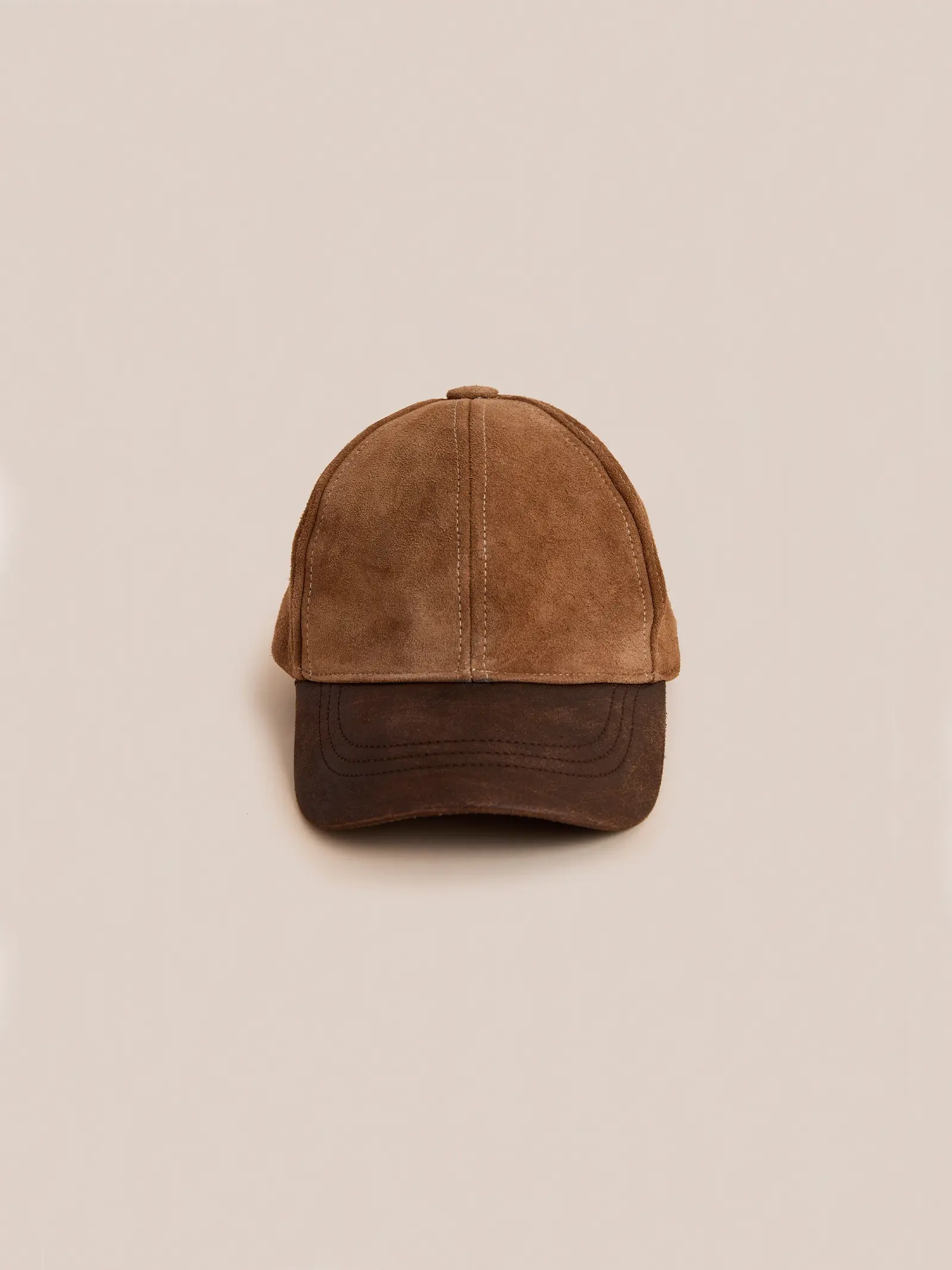 The Found Suede Leather Contrast Distressed Cap features brown suede with a distressed leather brim, shown against a plain beige background.