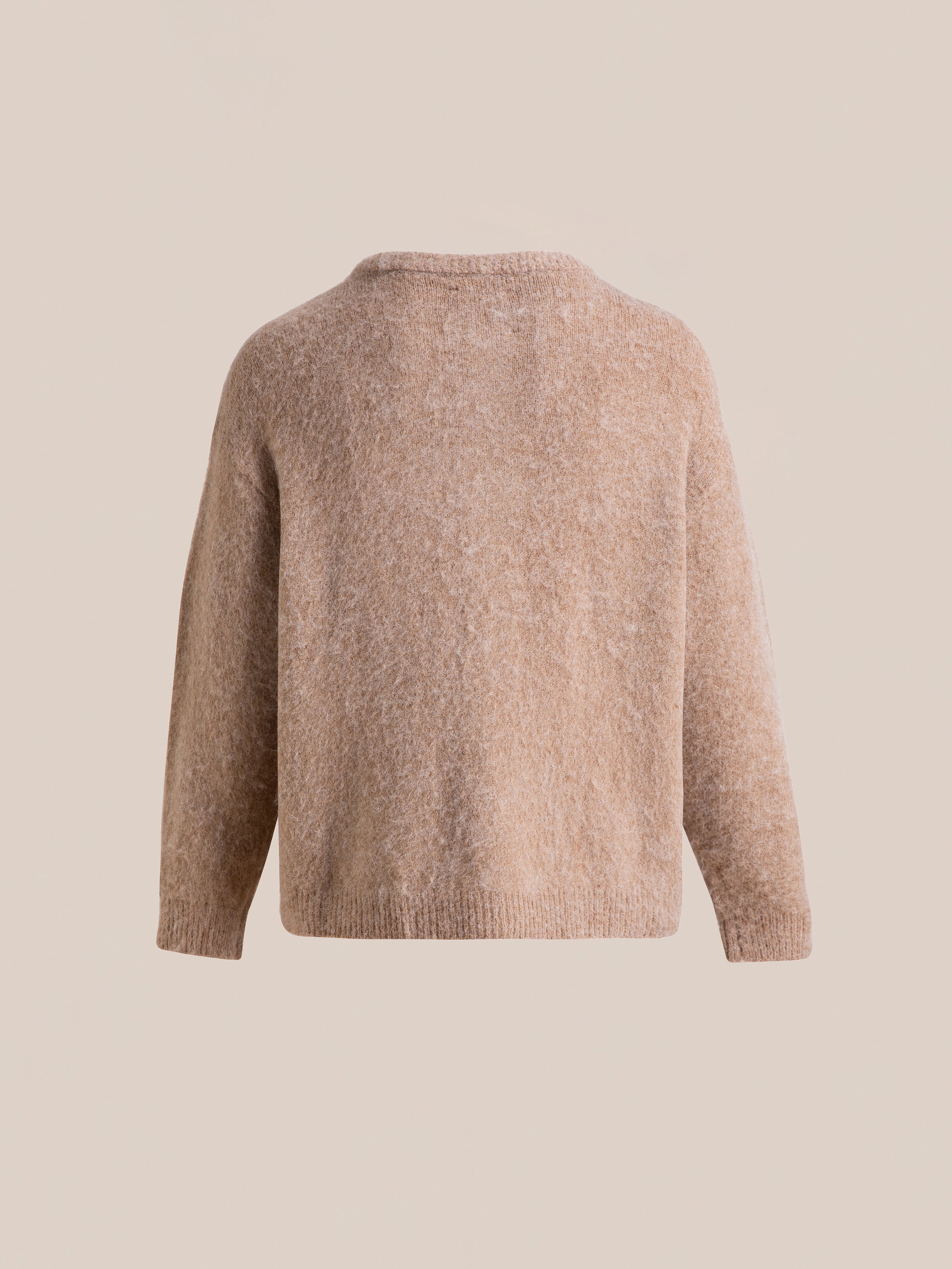 Back view of the FOUND Mohair Cardigan, a long-sleeved beige wool sweater with an oversized fit and tortoise buttons, against a light beige background.