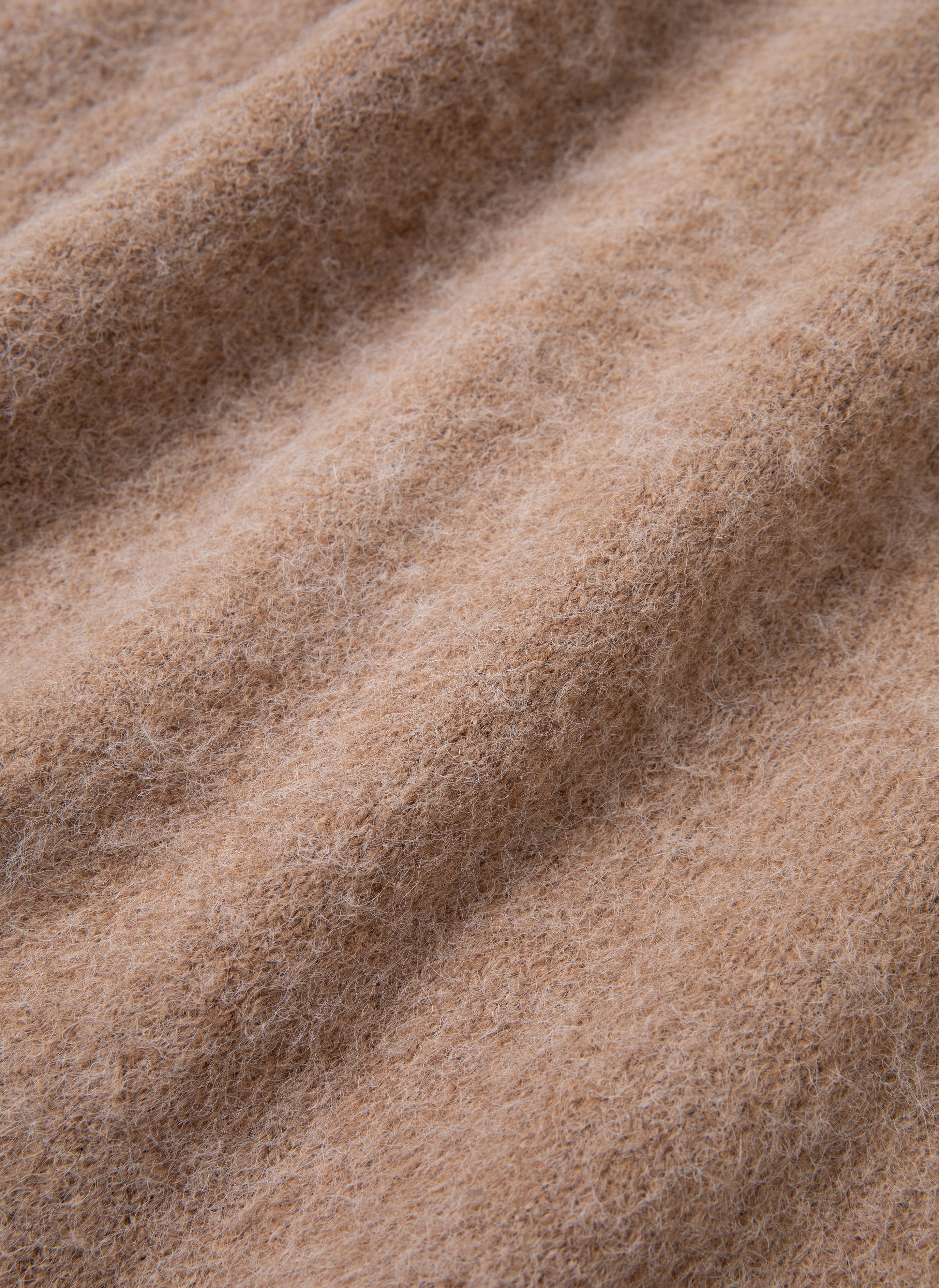 Close-up image of a soft, fuzzy brown fabric with a textured, wool-like appearance, reminiscent of the oversized fit FOUND Mohair Cardigan. Ripples and slight shading enhance the material's depth.