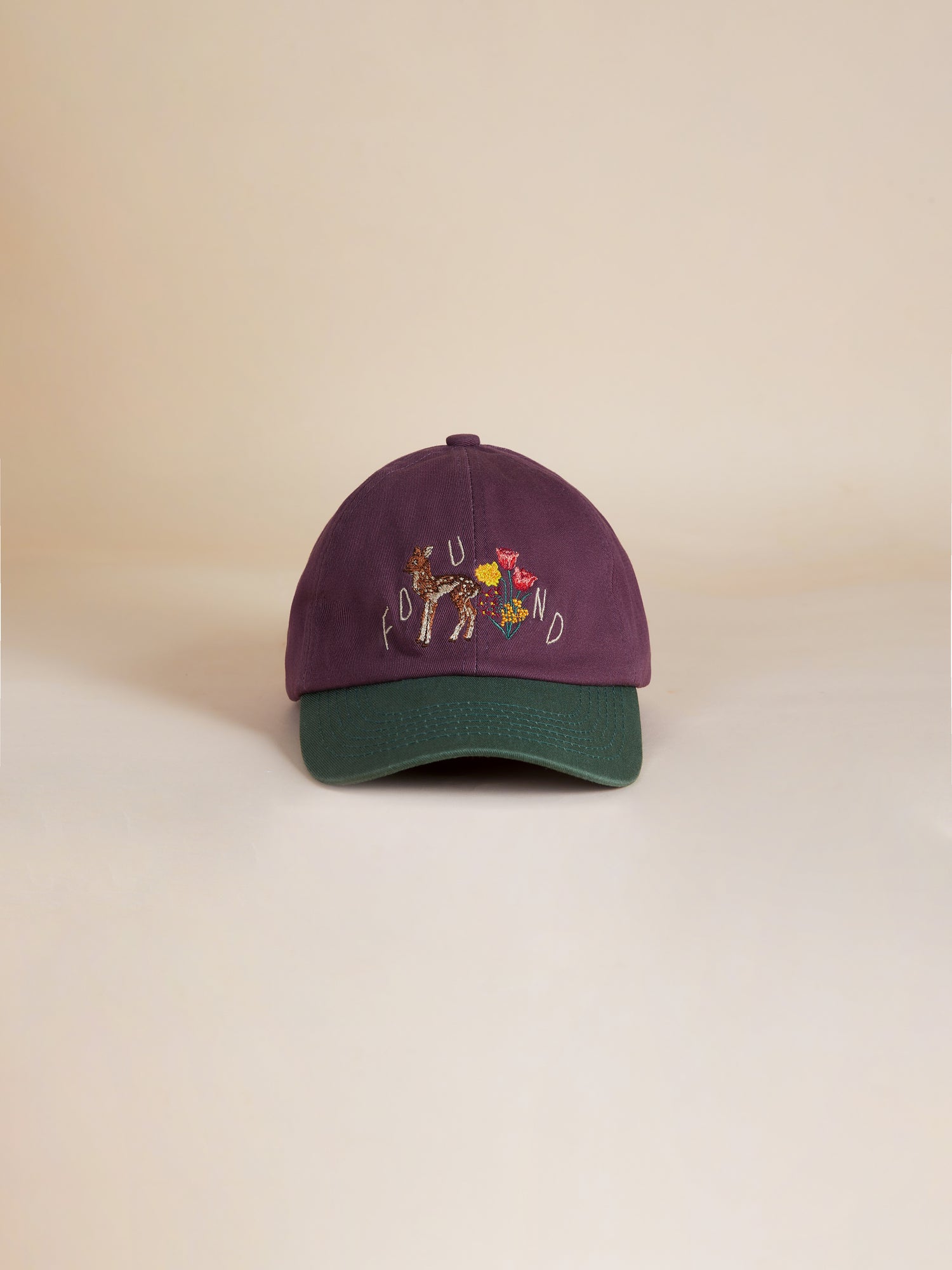 A purple and green Flower Deer Cap with a flower on it by Found.