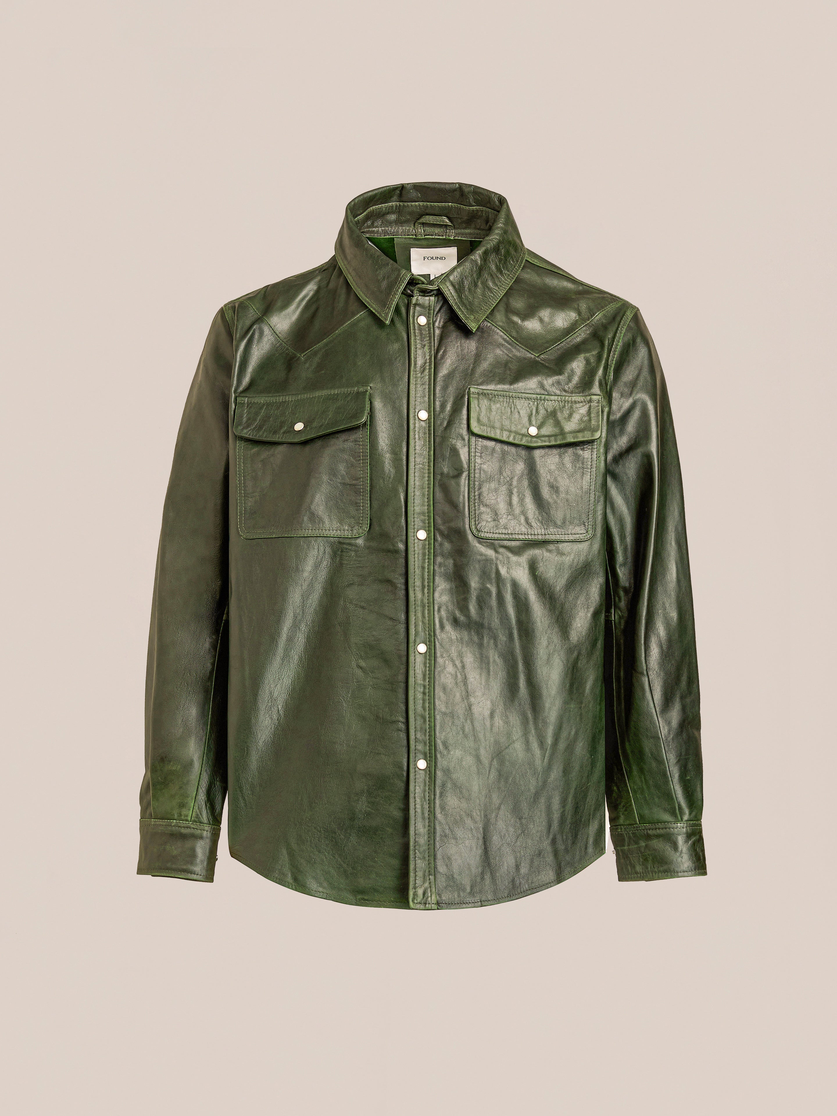 The FOUND Forest Leather Western Shirt, featuring long sleeves, a collar, button-down front, and two button-flap chest pockets, is shown against a plain beige background.